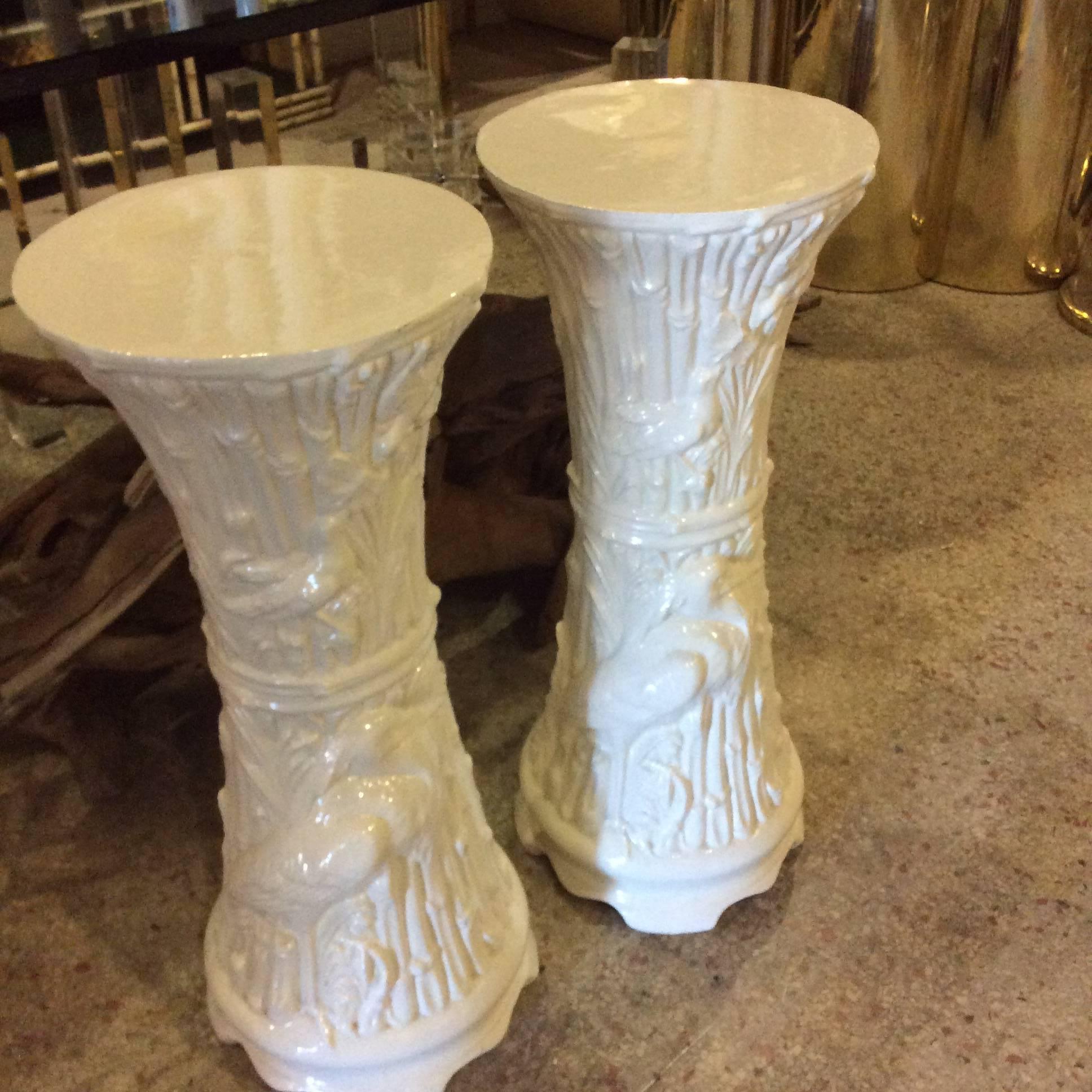 Lovely pair of vintage Hollywood Regency chinoiserie, white ceramic plant or garden stands with faux bamboo, birds, White Heron, leaves, etc motiff. Perfect as stands or tables. Great faux bamboo design details for a tropical palm beach feel.