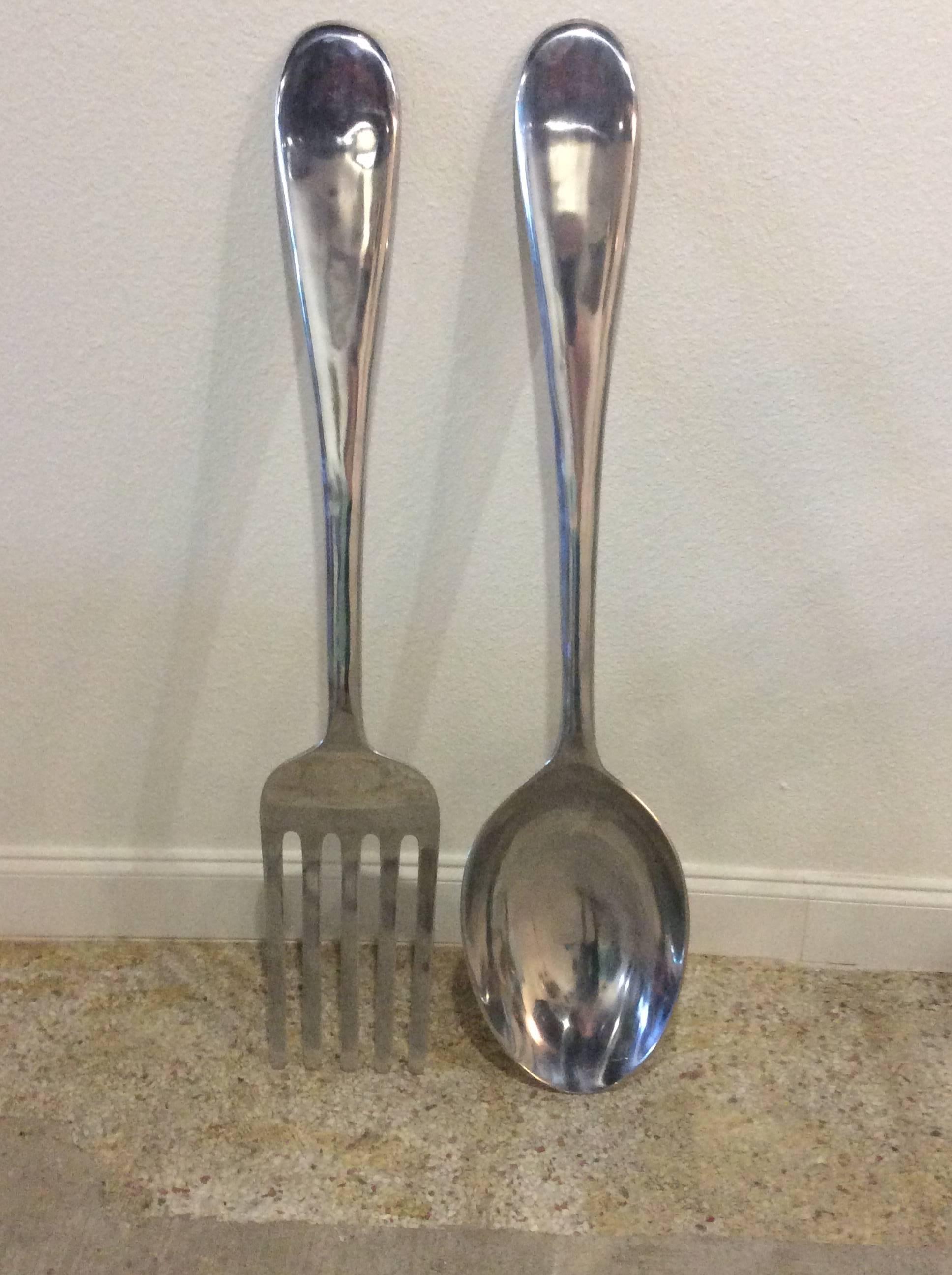 Vintage monumental oversized pair of chrome fork and spoon kitchen wall art in the manner of C. Jere. 
Spoon measures 46.5 T x 10.25 W x 3.5 D.
Fork size is below.

Hollywood Regency, Mid-Century Modern, retro., Palm Beach 