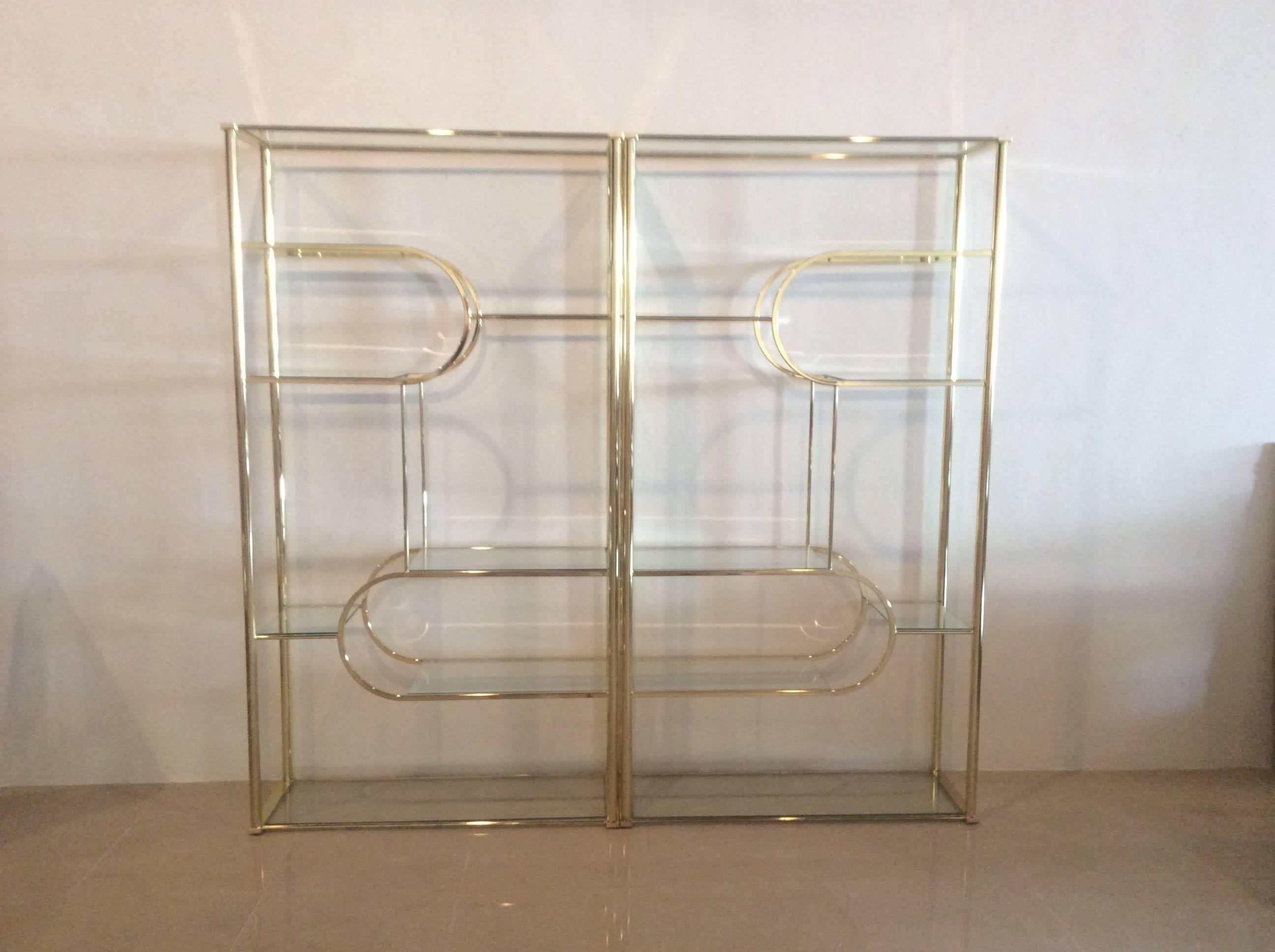 Amazing pair of vintage brass DIA Design Institute of America glass display shelves. This can be set up three different ways for completely different looks. This can be set up as two separate etageres, or pushed together. Depending on which ends are