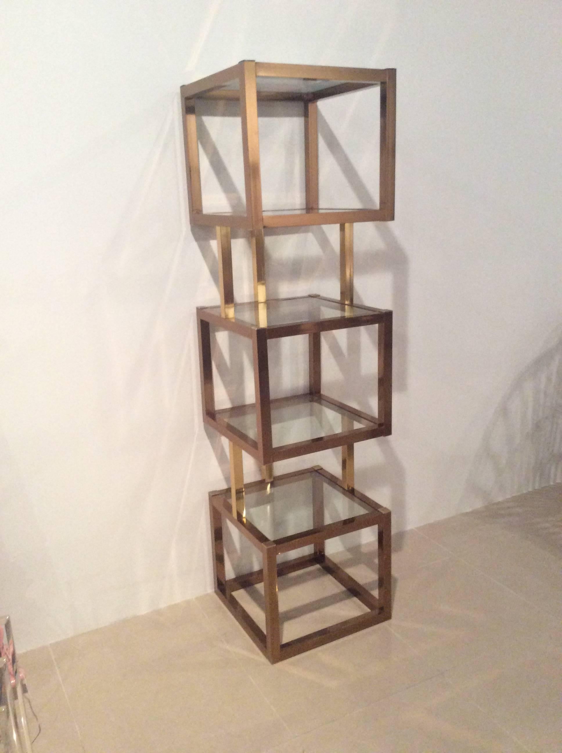 Vintage Hollywood Palm Beach Regency cube etagere shelf with five glass shelves for display. The cubes are in a rose gold color and the straight connecting bars are in a gold brass color. 
In the style of Milo Baughman.
