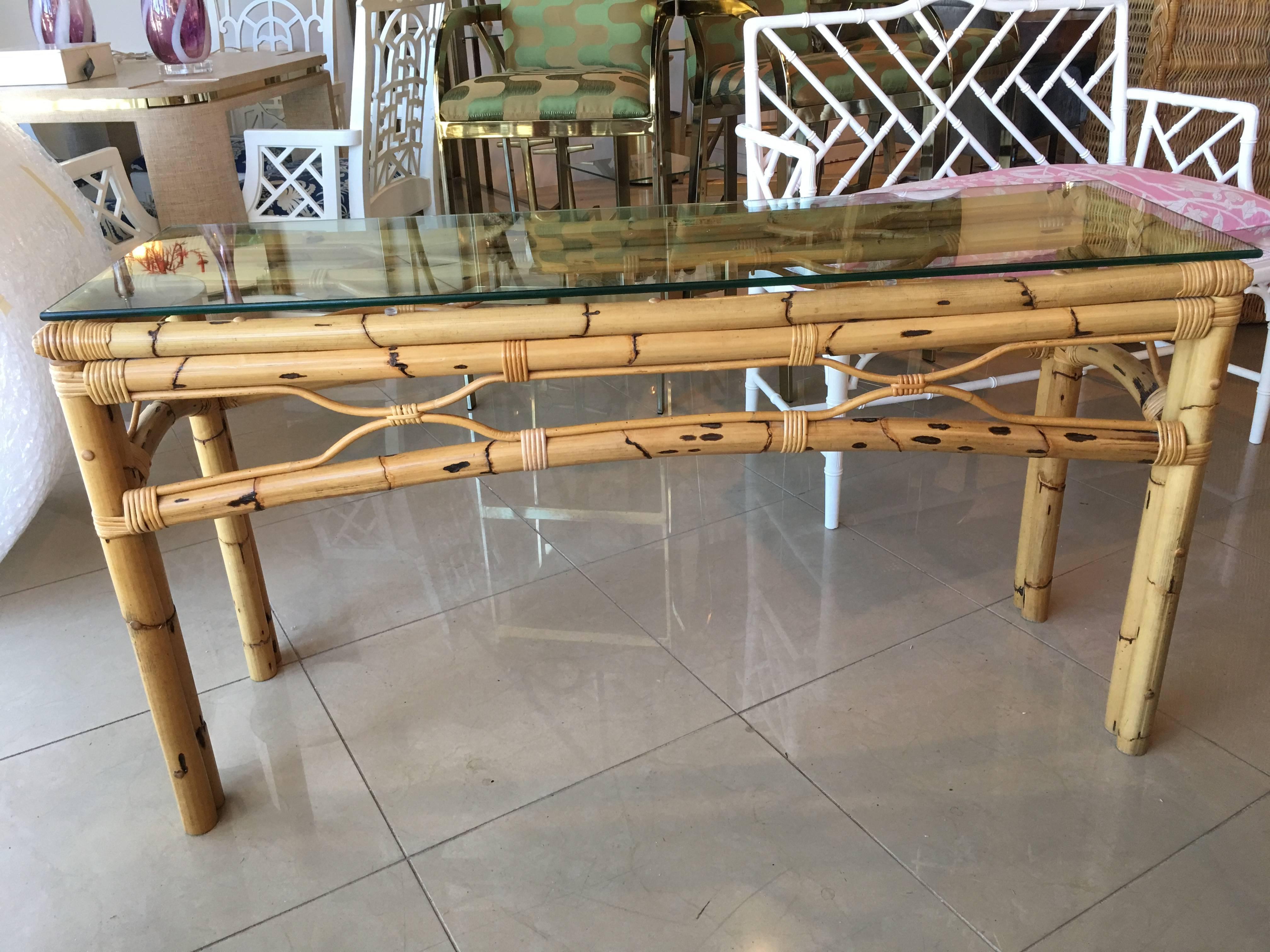 Vintage burnt bamboo rattan console table with glass top. Original glass top may have some surface scratches.
       