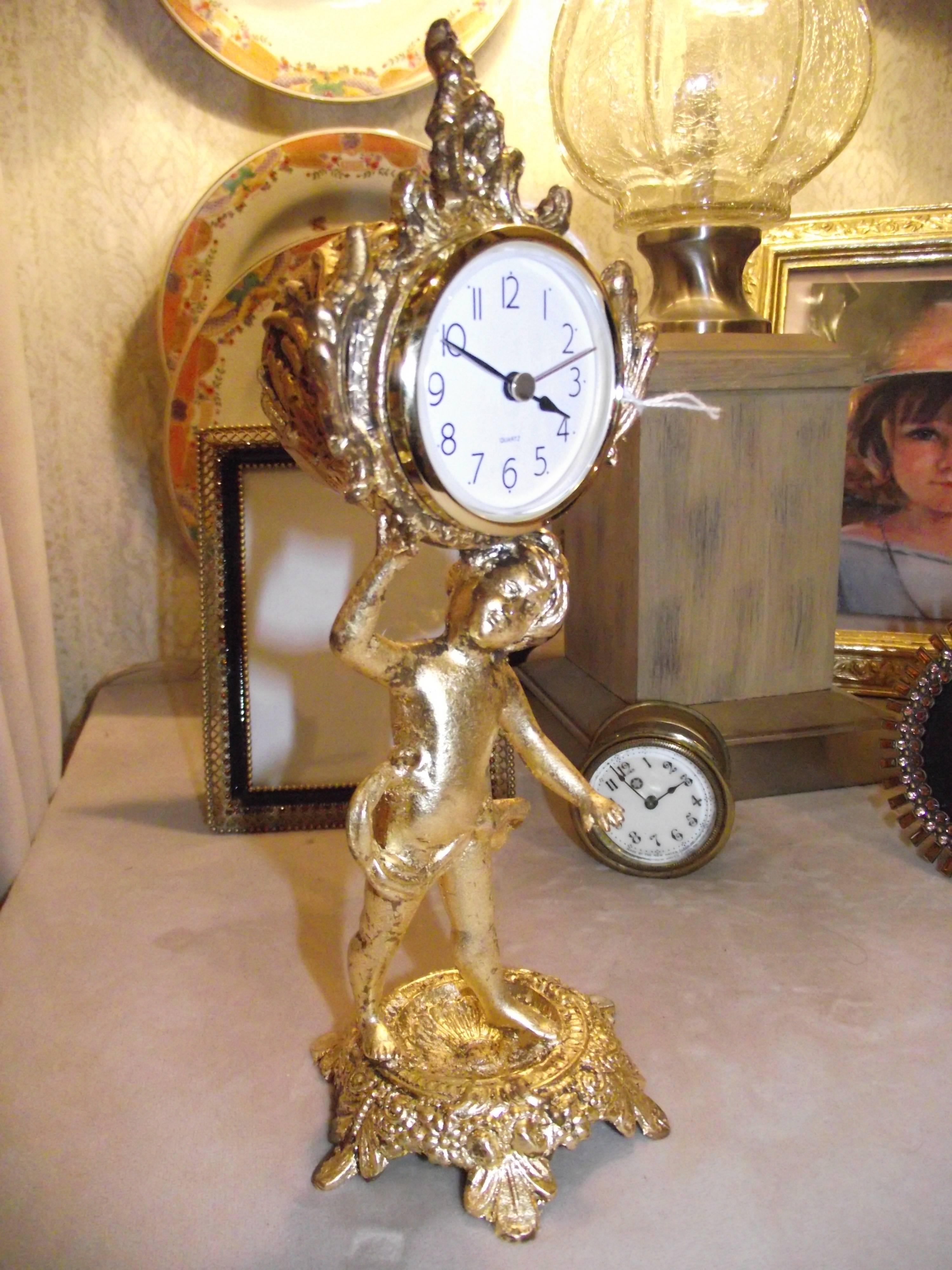This charming little clock is a perfect dressing table piece or a great table top or bookshelf piece.

It is made of white metal. The finish has been renewed using gold leaf appropriate to it's age.

It has been outfitted with a battery clock.