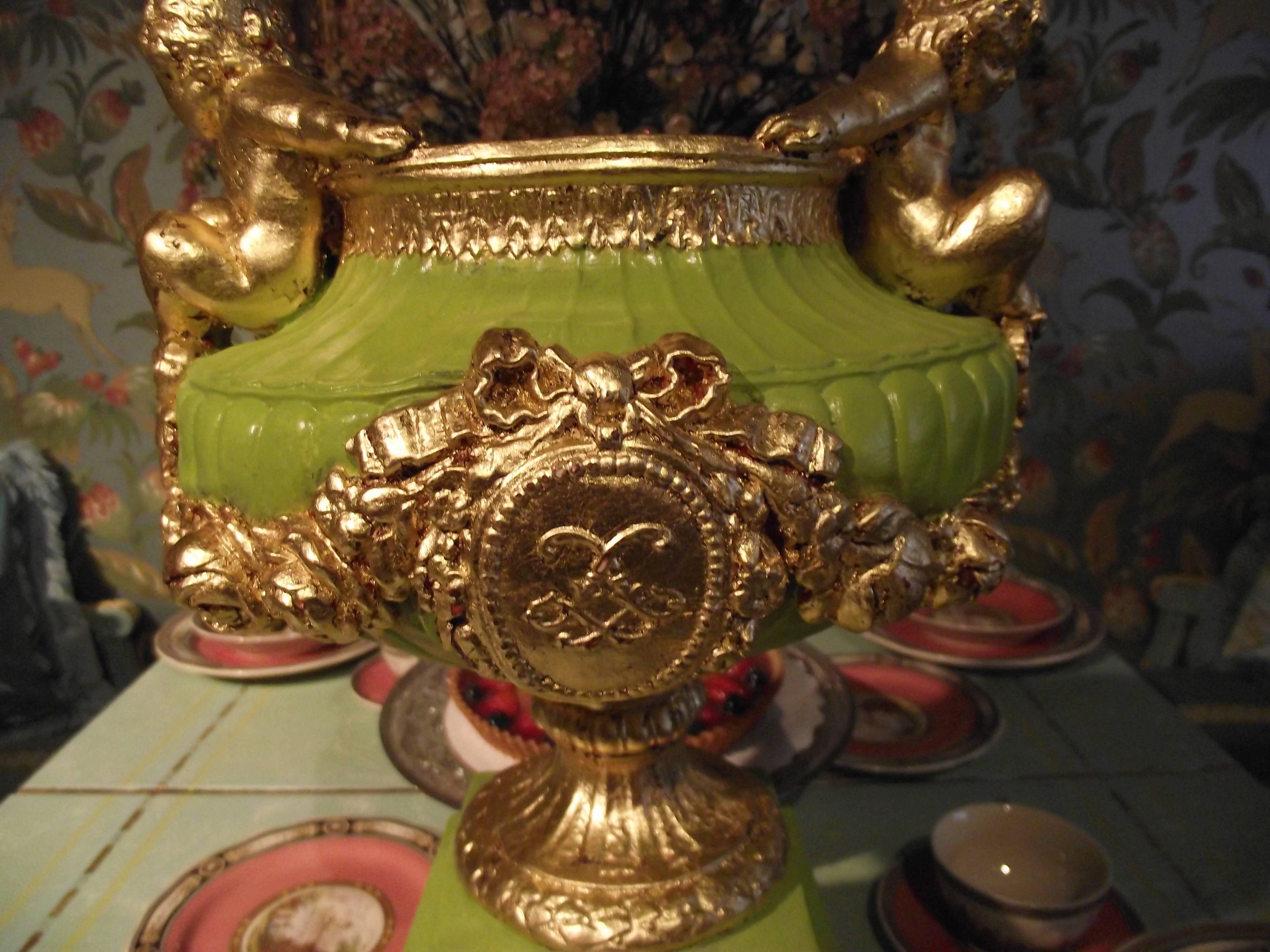 This striking urn has an original finish crafted in my studio. It was hand-painted and accented with hand applied gold foil leaf.

This plaster piece features a center medallion with floral swags coming together on each side at the feet of