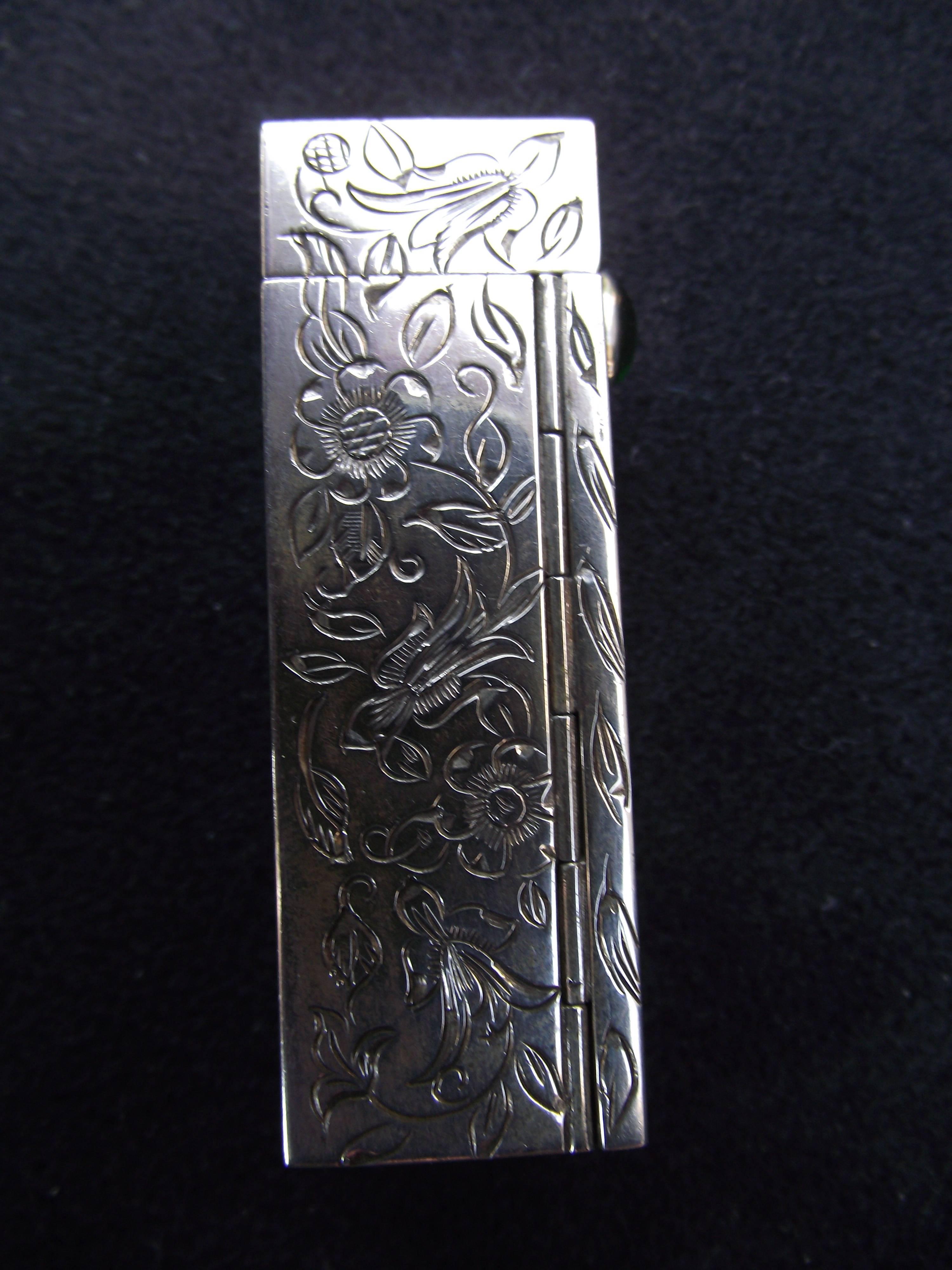 Two exquisite sterling silver lip stick cases with pop up mirror for your consideration. All four sides are elaborately adorned with leaf and flower designs. One has a green stone and the other a turquoise stone.

While we know a lady should not