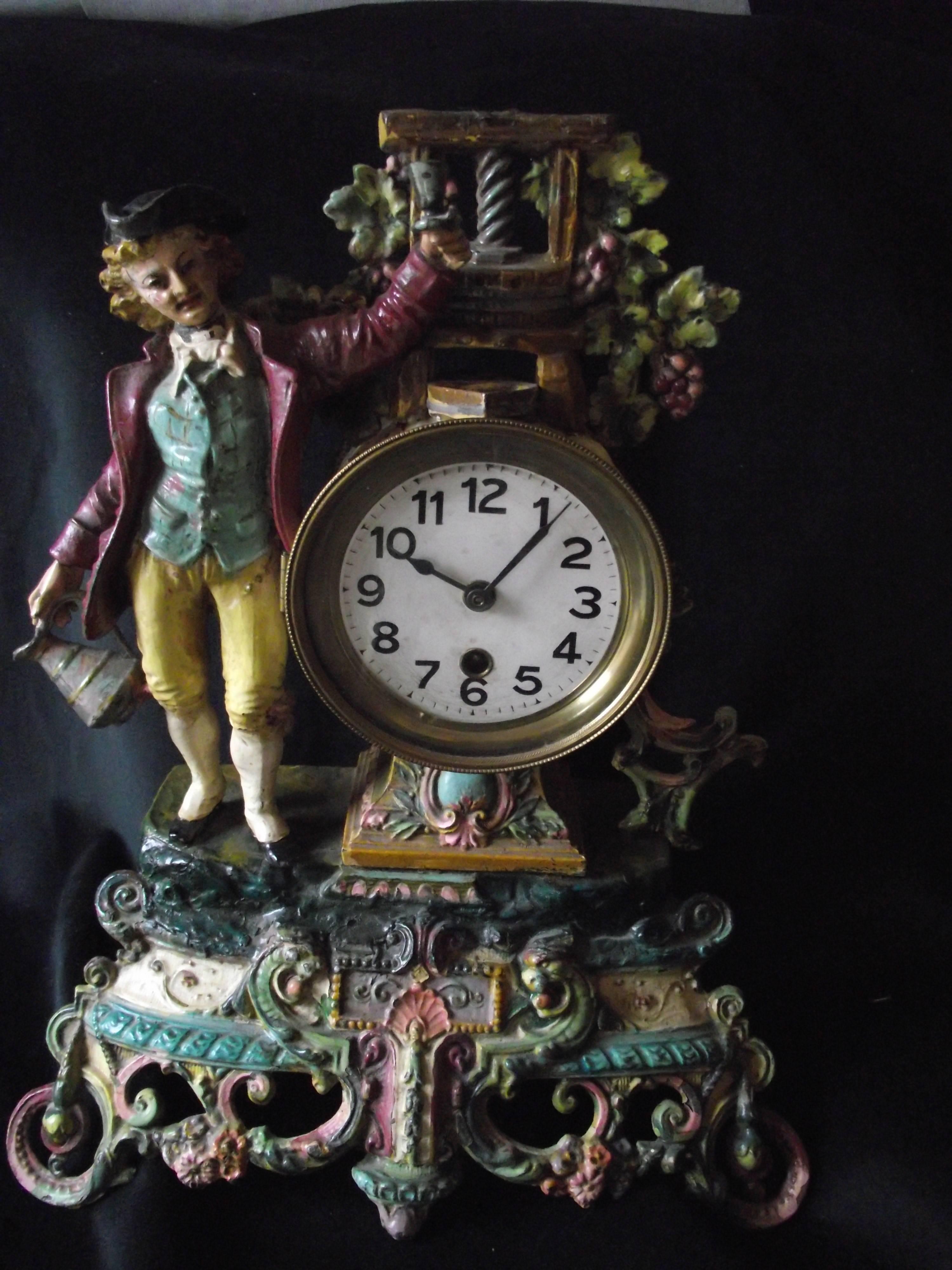 This beautiful antique painted clock features a jolly fellow toasting a good year's grape season in front of the wine press. These painted metal clocks are rare finds.

The clock works are a one day wind, time only. Movement of uncertain origins.
