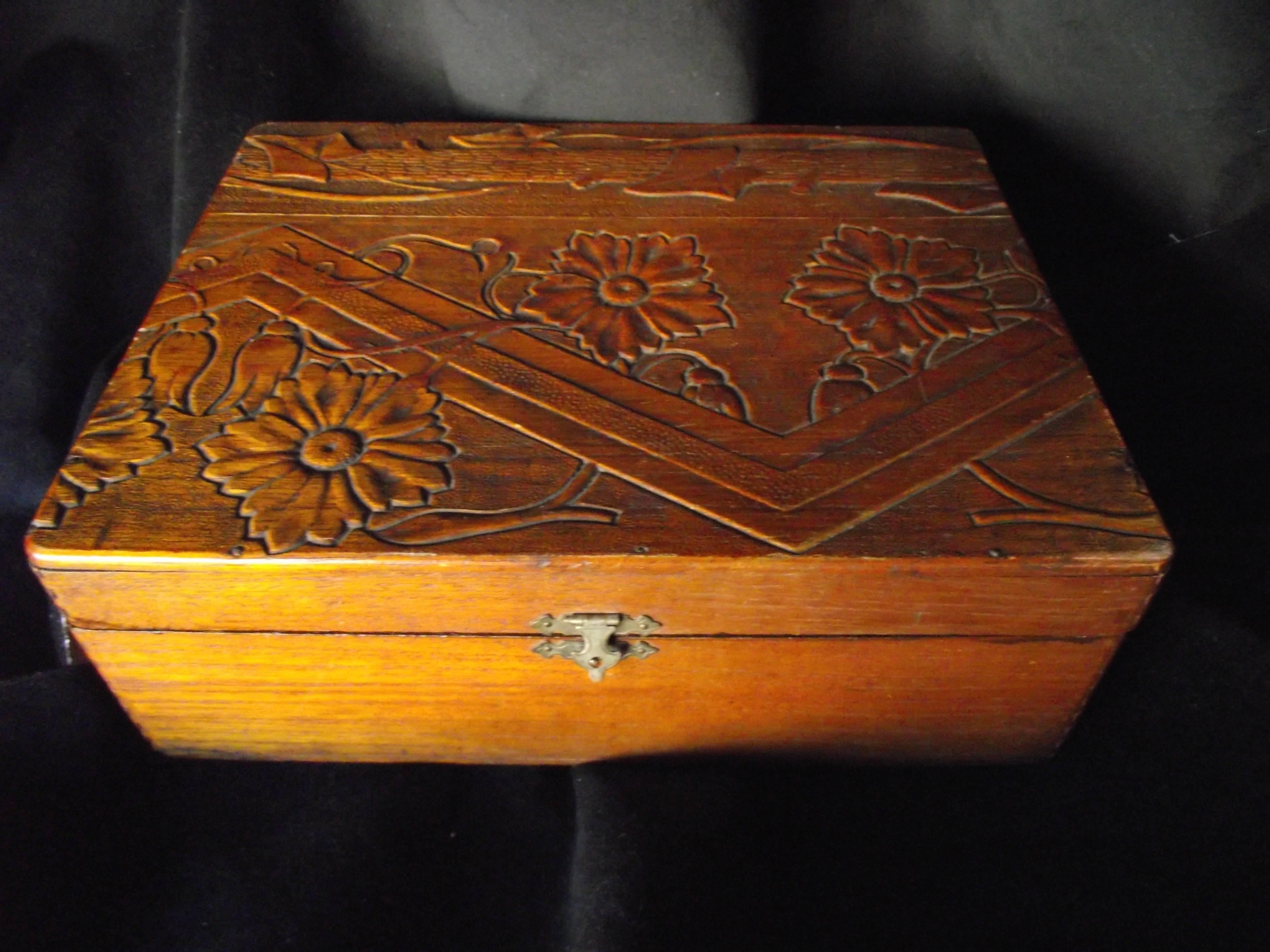 This beautiful box appears to be an early Art Deco box. It features a typical Deco angle design but also includes floral and ivy designs. The over all design is reminiscent of late Victorian designs by William Morris. 

The craftsmanship that into