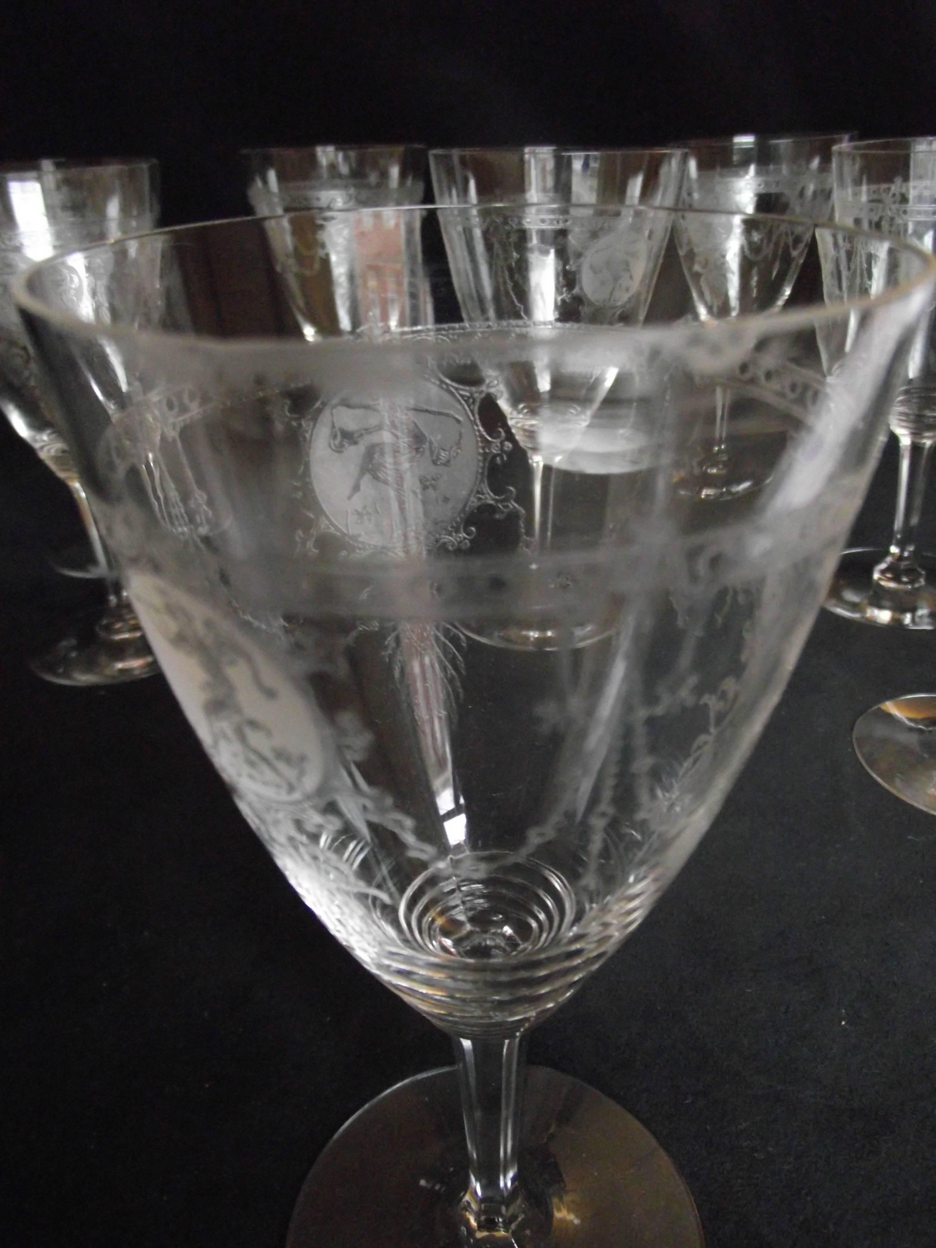 This set of eight wine glasses are by Heisey. The pattern consists of three medallions. One contains the piper, one; a boy dancer and one containing a girl dancer. The medallions are connected by a swag design. One glass has chips on the rim which