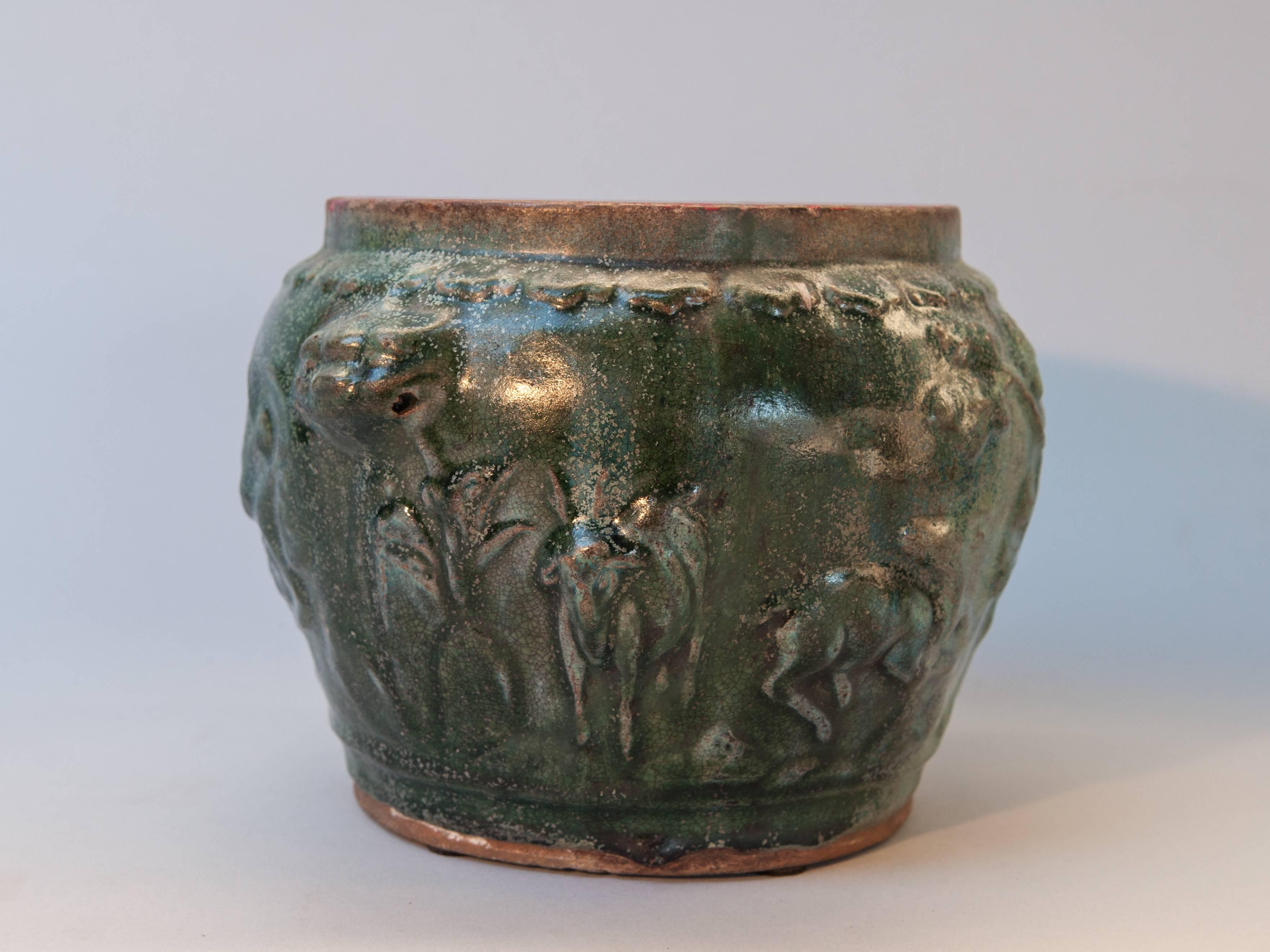 Green glazed pot from Southern Thailand found off Java, late 19th century
This small pot has a lovely multifaceted green glaze and is decorated all around with auspicious three dimensional motifs cherry blossoms, dragons, a deer, an elephant and