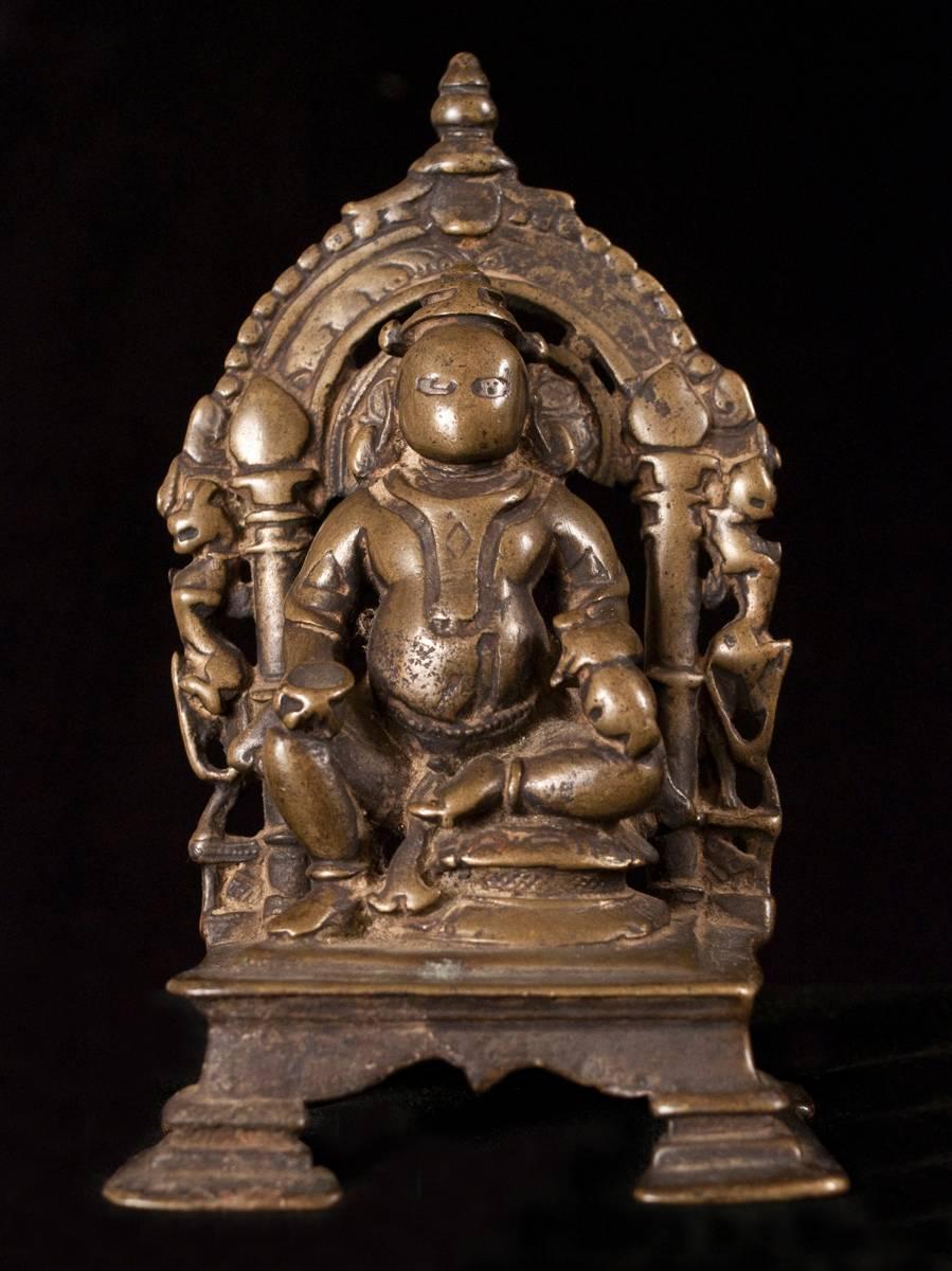 13th-16th century bronze shrine for Kubera from India.

This is a small lost wax cast portable bronze shrine of Kubera, the god of riches and guardian of the north. He is short and portly and holds what seems to be a bowl in his right hand and