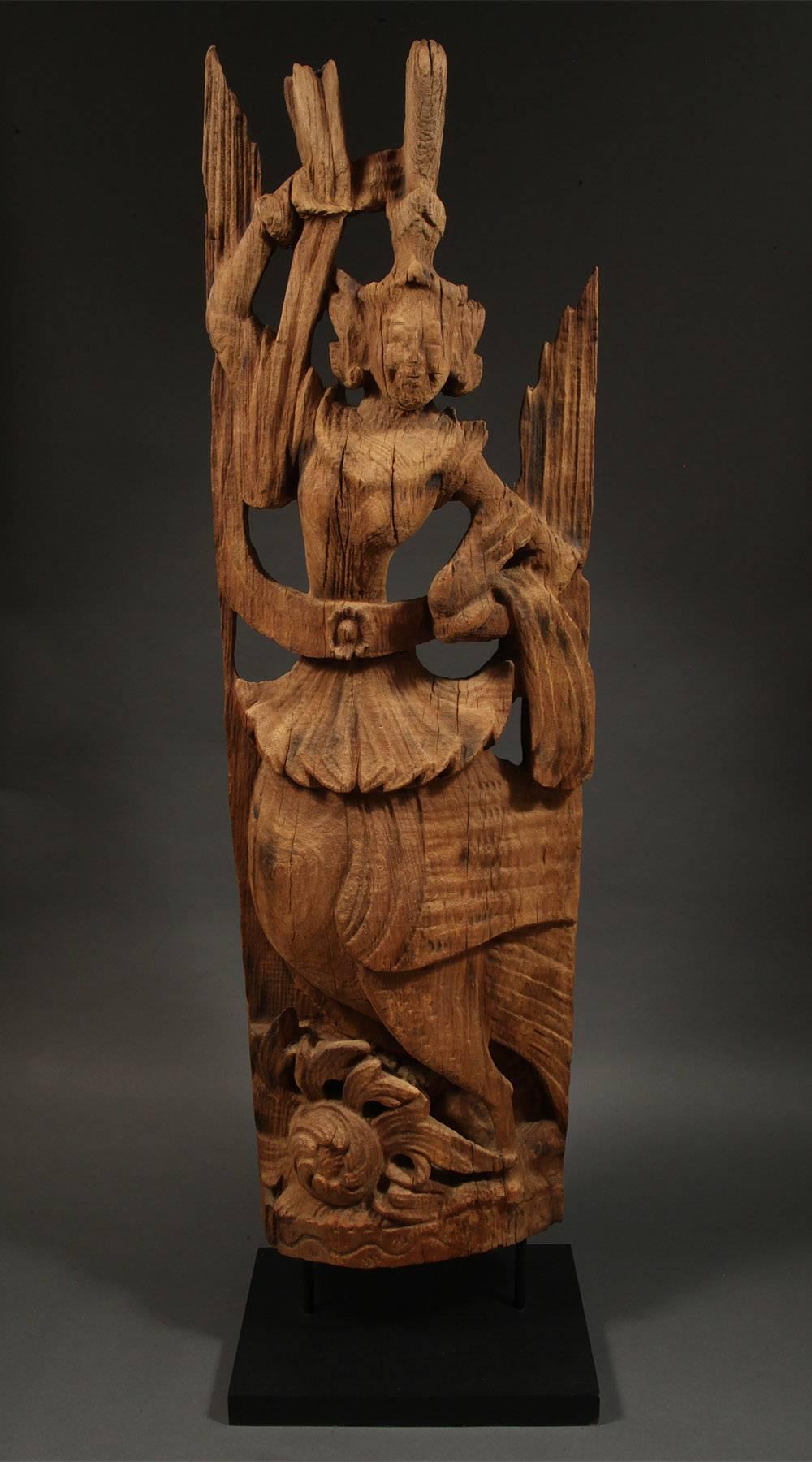 Early 20th century carved wood Kinnari (female) figure, Burma.

The magical half-human, half-bird figures likely came to Burma through Indian literature and the spread of Buddhism. They are known for their physical beauty, glorious plumage, grace