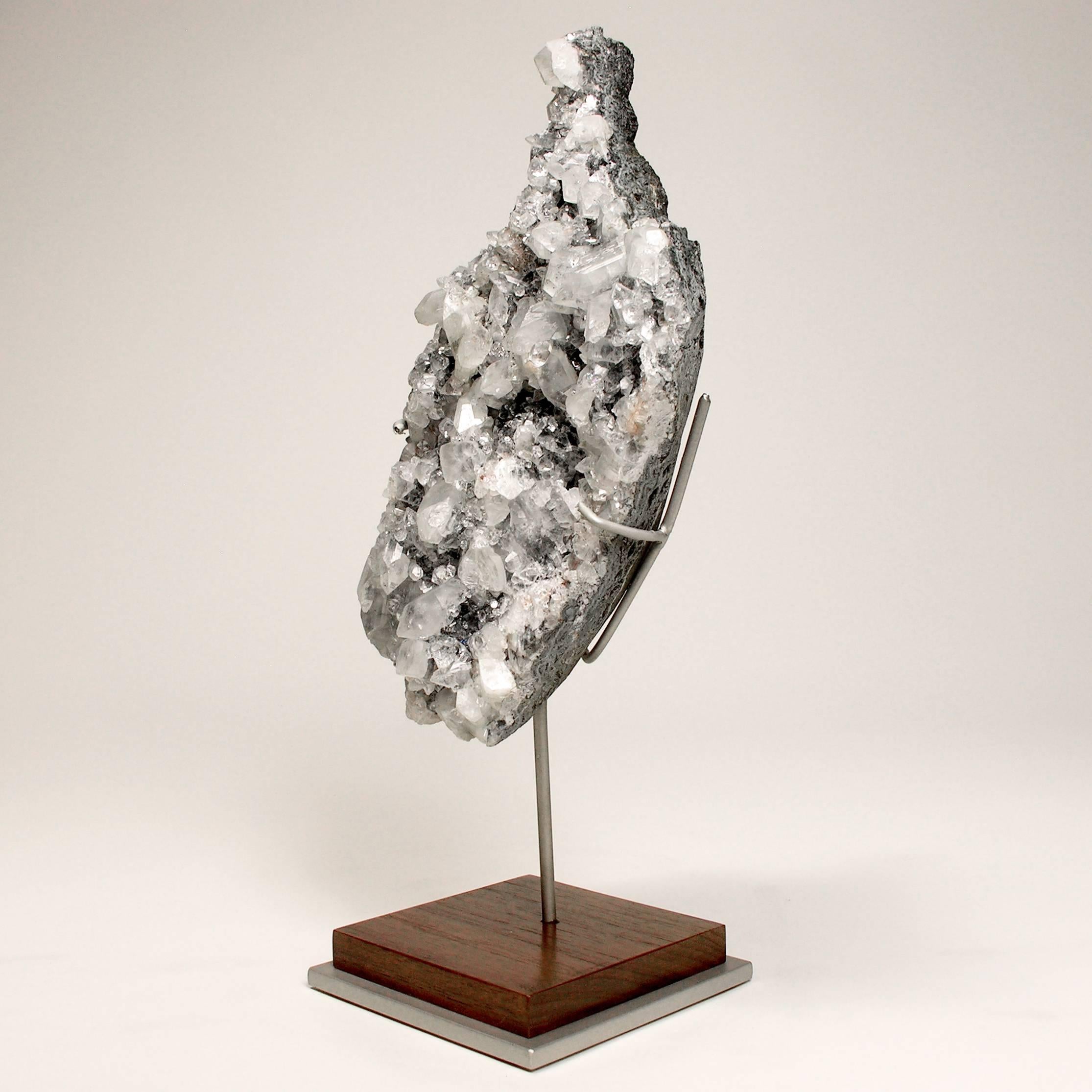 Mineral specimen sculpture Apophyllite grown on a crystal base
  
The abstract brilliant form hints at a dazzling figure. Part of a geode, mined in India. Custom mounted on a walnut and nickel painted armature.
  
