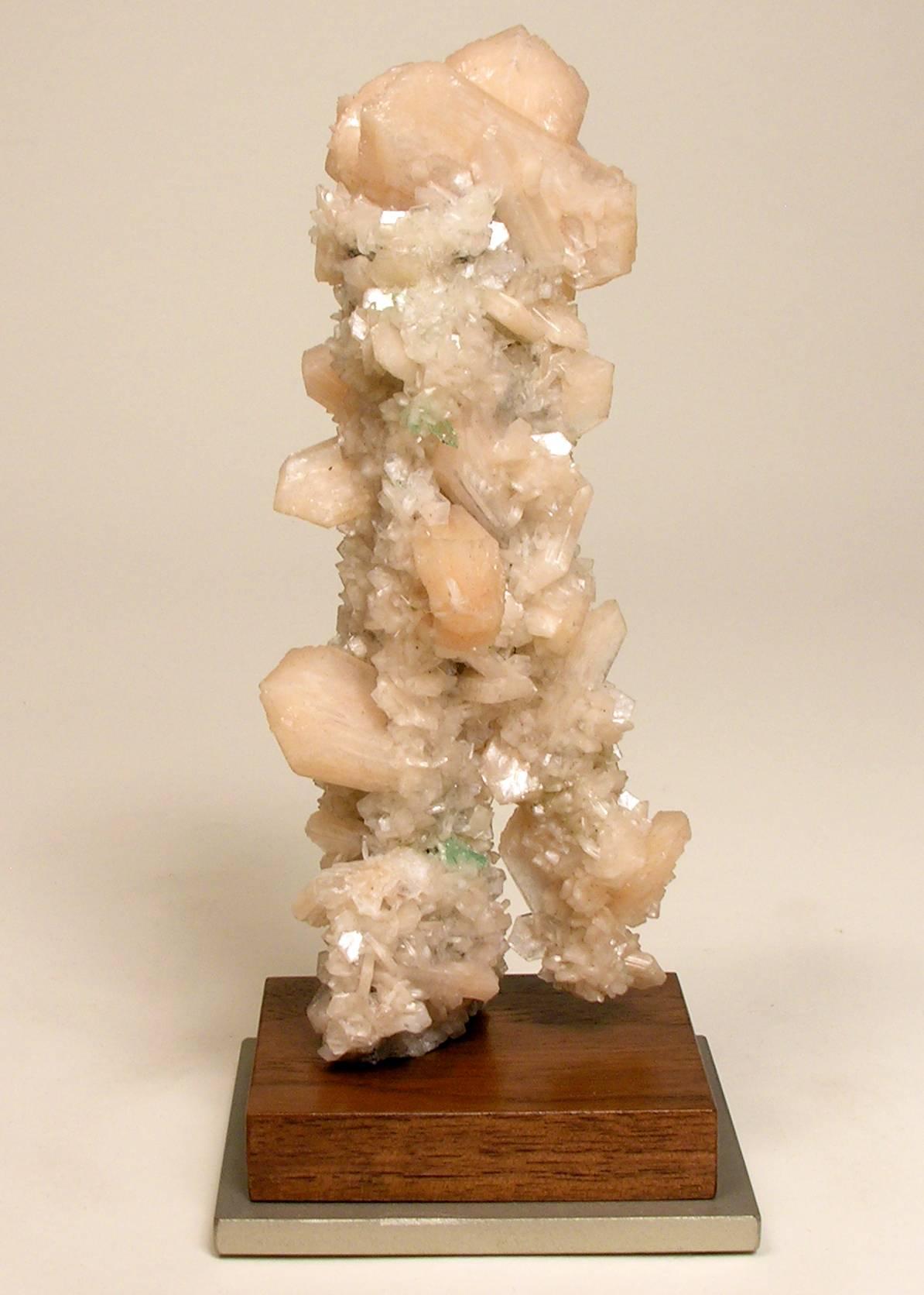 Naturally formed mineral peach stilbite on apophyllite sculpture

A mineral specimen in the form of an abstract walking figure. Mounted on a custom walnut and satin nickel painted base.
Custom basing options available with an additional fee. 