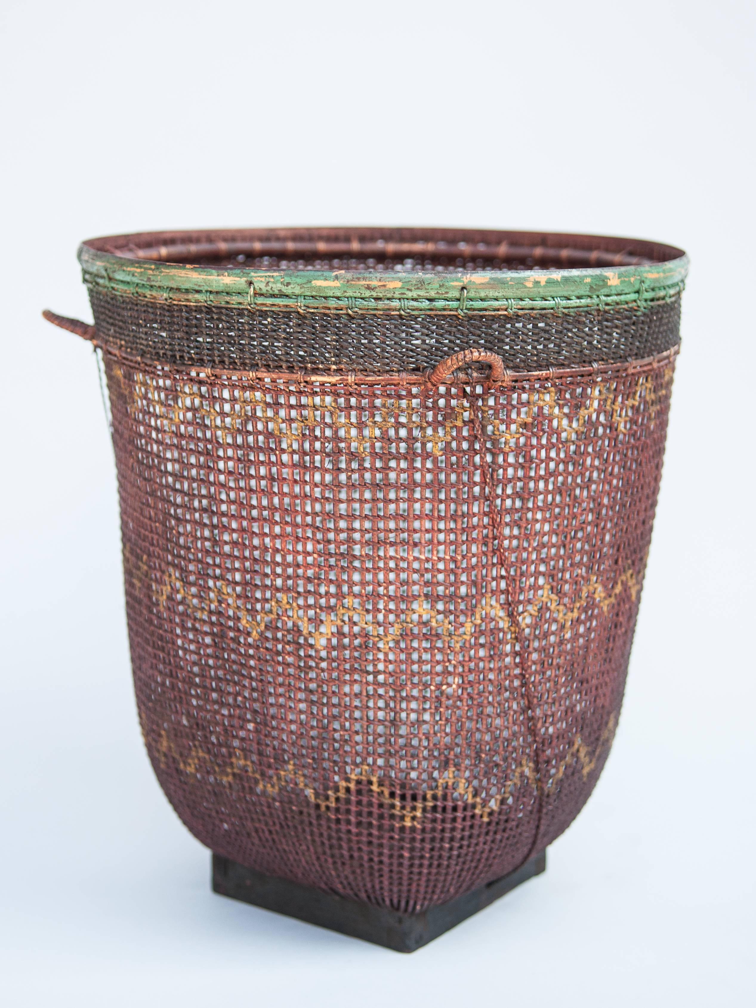 Tribal storage and carrying basket Palembang Sumatra, mid-late 20th century.
Bamboo basket from the Palembang area of south Sumatra; finely woven of strips of bamboo and with painted designs and original color. It incorporates a narrow wooden base