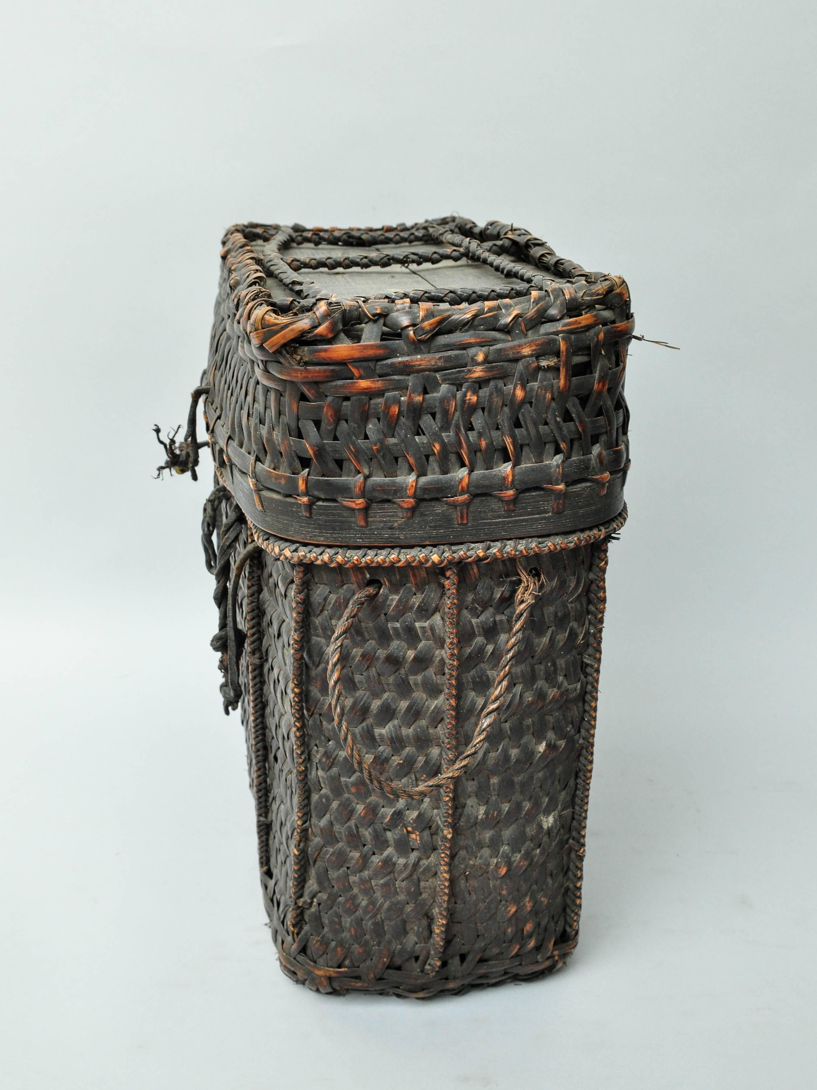 Tribal storage and carrying basket with lid from Bhutan, mid-late 20th century
Handwoven of bamboo with wood incorporated into the base and top for added strength. This strong rustic basket would have been used to store and transport household good