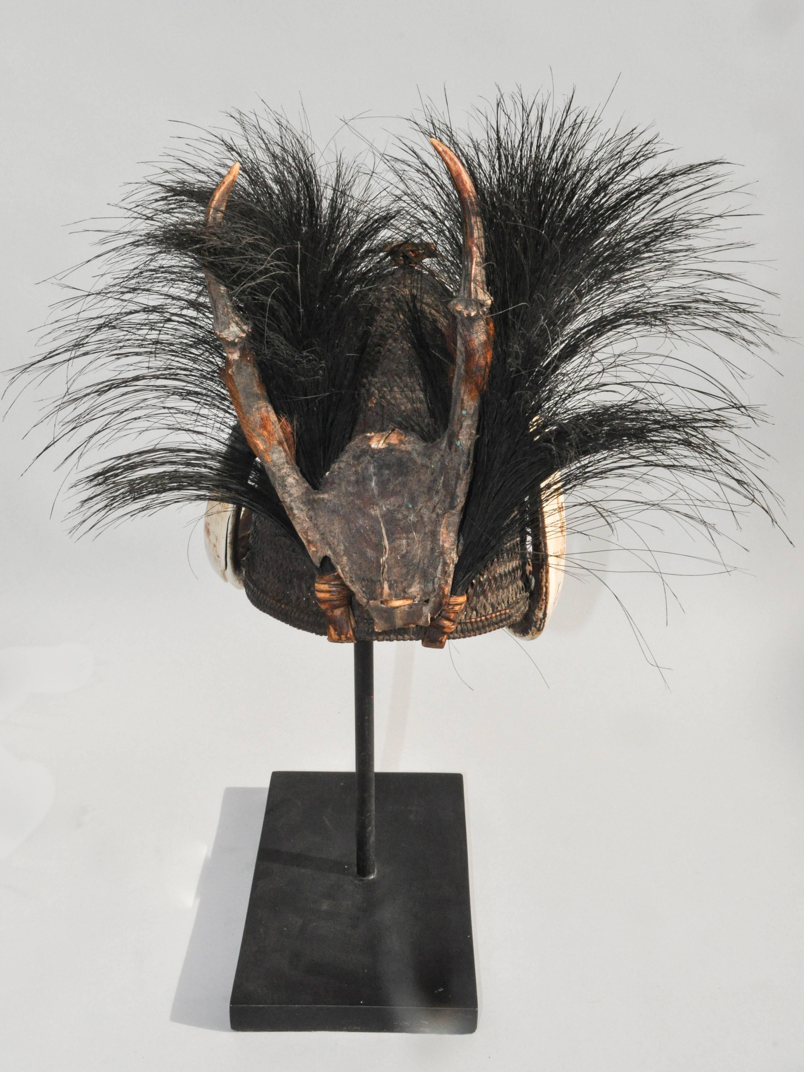 Rattan hat with boar tusk goat hair & Antler. Konyak Naga. Mid-20th Century. Mounted on a stand.
Offered by Bruce Hughes.
This is a ceremonial warriors hat from Nagaland, attributed to the Konyak Naga, but it may have come from any of a diverse