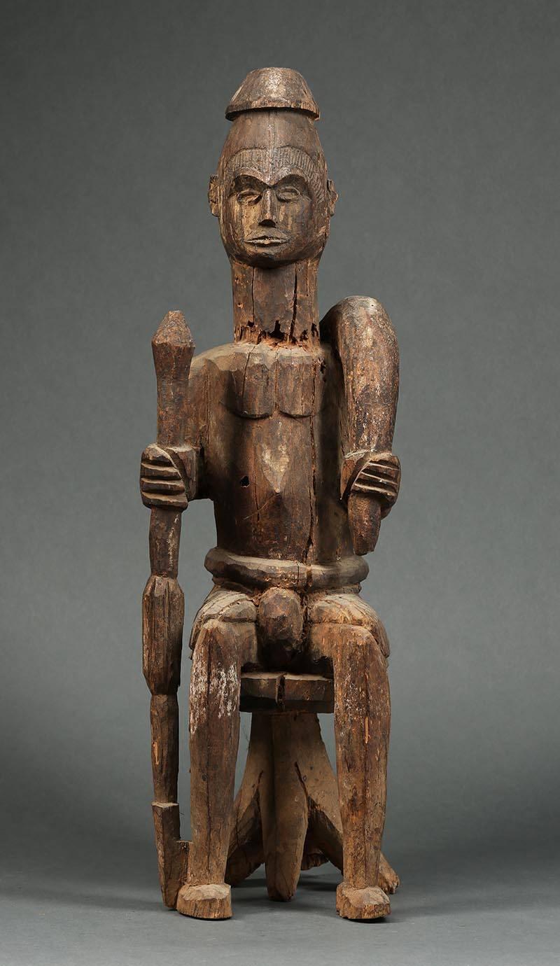 Offered by Scott McCue
Large tribal seated Igbo Ikenga figure with sword, early 20th century, Nigeria

Large Ikenga figure from a shrine, seated on classic for four legged stool, holding curved sword and staff with strong expression. Carved of