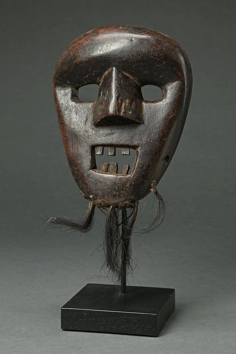 Tanzanian Hehe People Tribal Dance Mask, East Africa, early 20th century

Heavily used expressive Hehe dance mask with open eyes and mouth, inset metal teeth, remains of hair beard. Deep patina with worn polished surface on front, and wear from