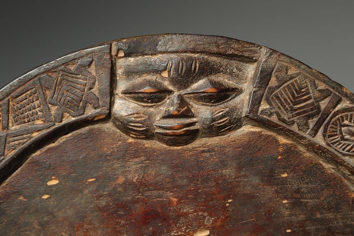 Offered by Scott McCue
Yoruba round tribal divination board with Eshu face, Nigeria, Africa, early 20th century.

Round, flat, hand-carved wood tray used by the Yoruba of Nigeria for divination and as a means to contact the spirits, with the face of