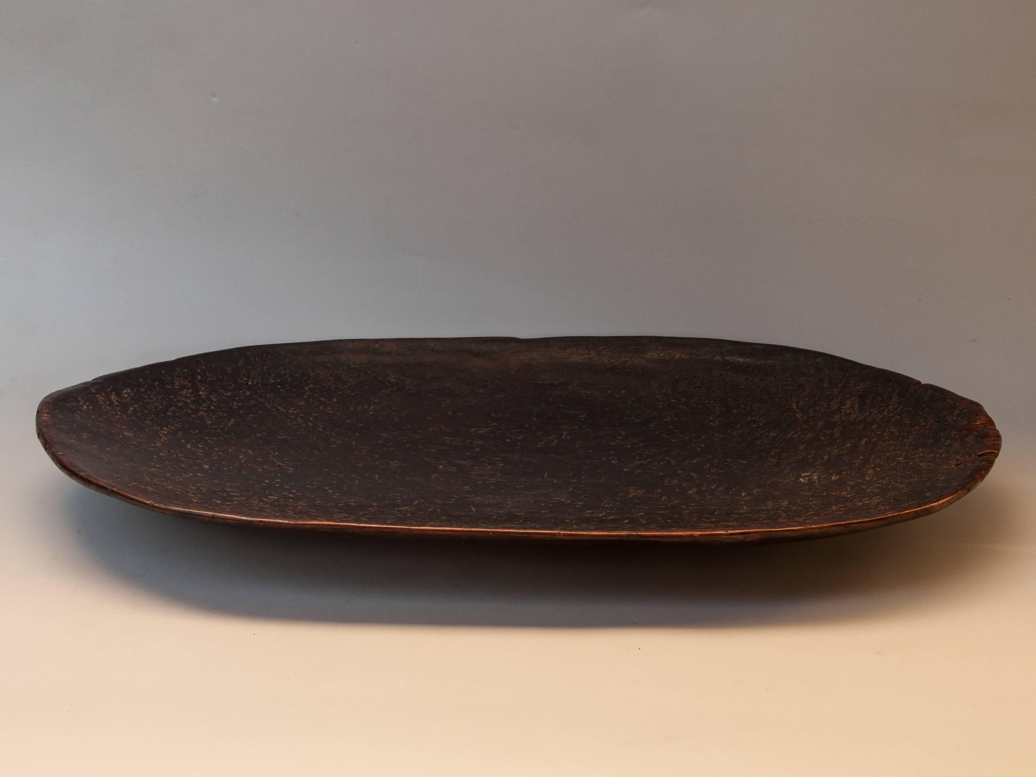 Tribal hand hewn wooden tray Mentawai Island, mid-20th century.
Fashioned by hand from a single piece of local hardwood, this oblong shallow wooden tray was used to present food and fruits when receiving guests. The shape is particular to these