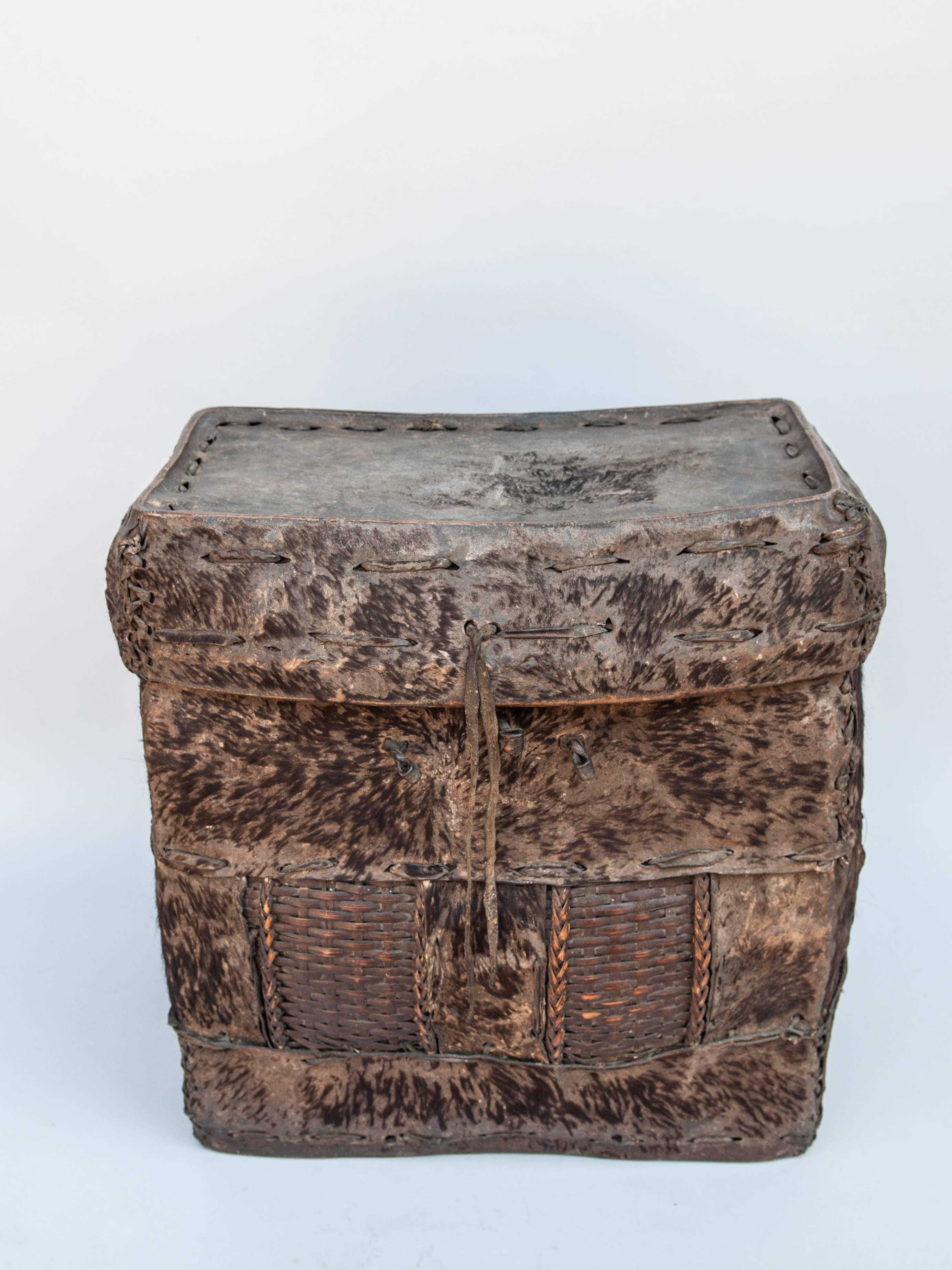 Tribal Storage Basket with Lid. Bhutan. Early to Mid-20th Century. Hide & Bamboo. 
A handwoven rugged bamboo frame covered with hide, comprises this extremely robust rustic storage basket from Bhutan. This basket would have been used to store and