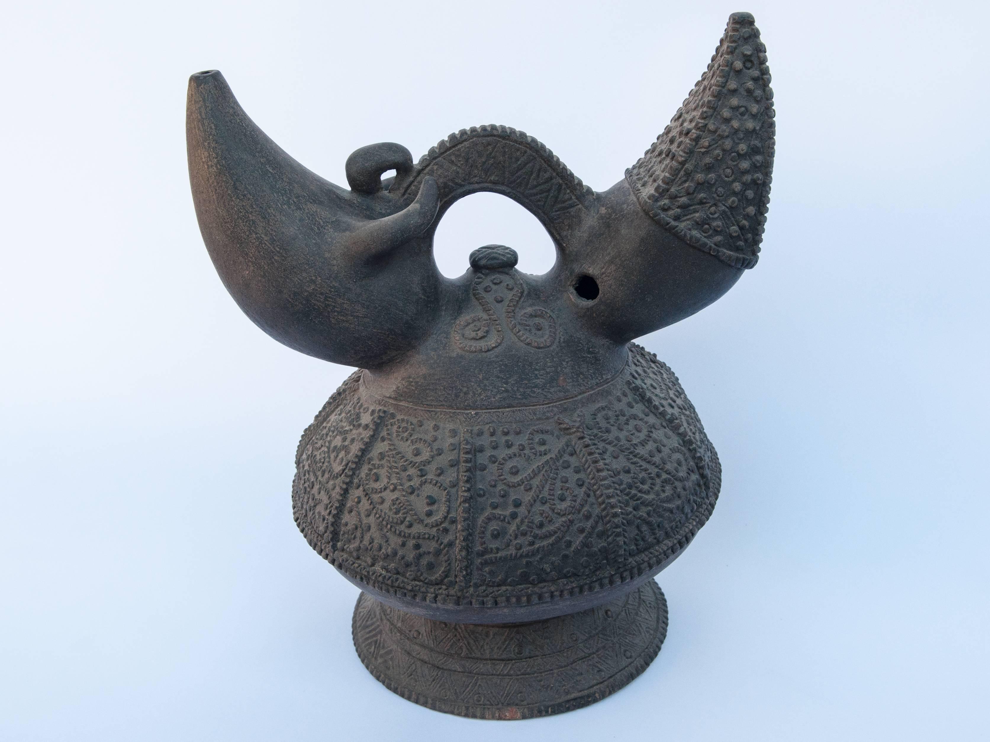 Earthenware Kendi with Raised Design. Lampung Sumatra. Early to Mid-20th Century.
Kendi are pouring and drinking vessels found throughout Southeast Asia since ancient times. They are used in day to day life, and also for ritual purposes. This