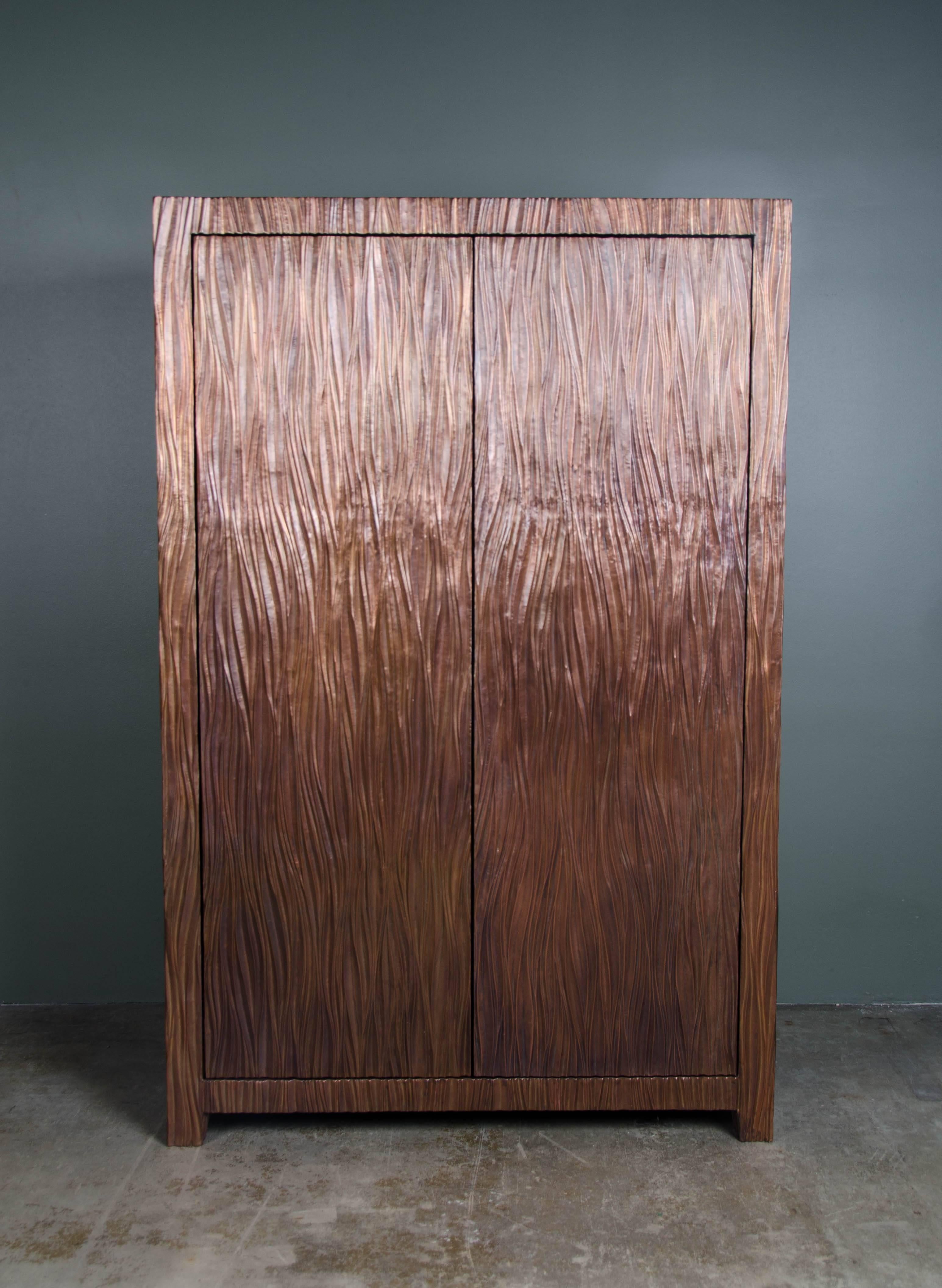 Pleats design armoire.
Hand repoussé copper
Antique copper finish
Wood interior 
Limited Edition
Customizable

Repoussé is the traditional art of hand-hammering decorative relief onto sheet metal. The technique originated around 800 BC between