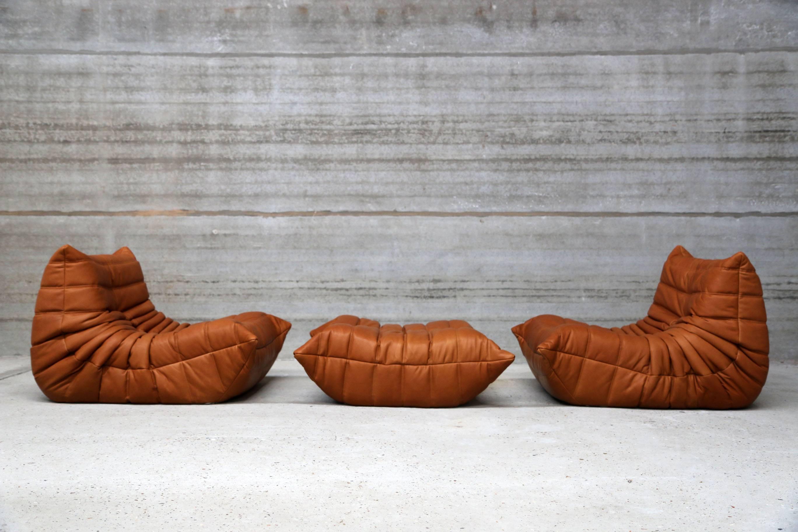 Two single seat lounge chairs and pouf, model Togo from Ligne Roset designed by Michel Ducaroy.
Re-upholstered in our signature full grain cognac leather. Our leather is biologically colored and feels warm and comfortable. Top