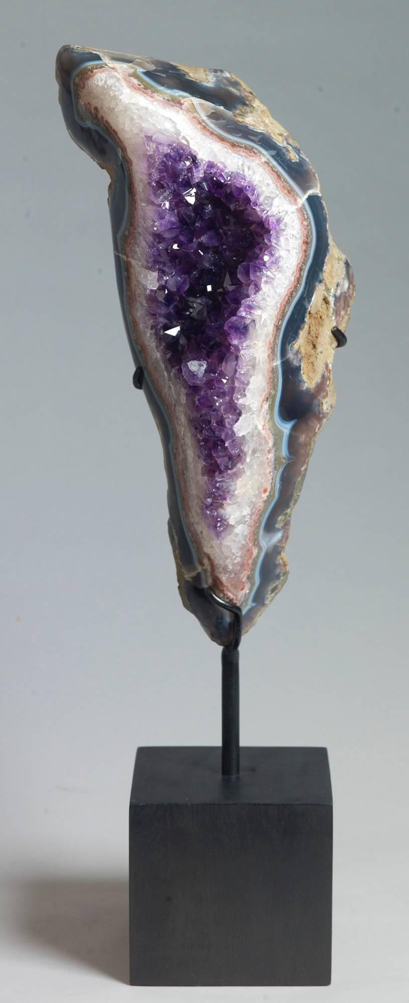 A large and beautiful example of amethyst on red and grey banded agate. Measures: 49 x 15 x 13 with stand.