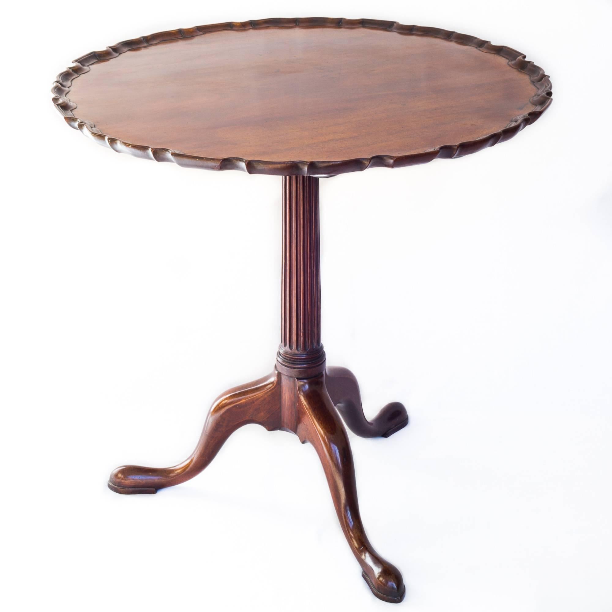 A fine mid-18th century Chippendale period small mahogany tripod tea table with circular and pie-crust moulded tilting top, raised on a turned and finely fluted stem above three gracefully curved supports ending in pointed pad feet. Rare in this