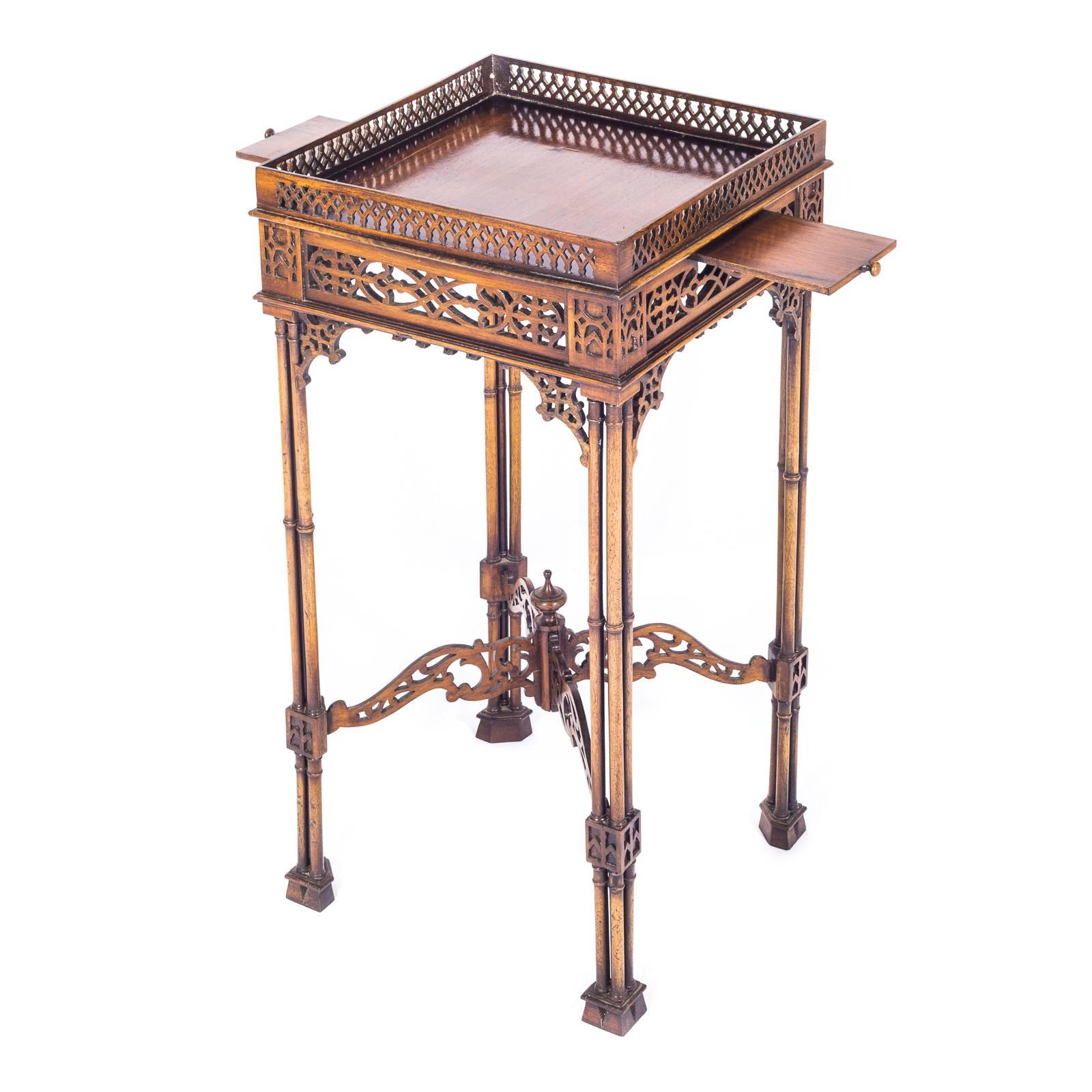 An attractive Chippendale Revival Table or Stand in Mahogany

The square fret-galleried top above a pierced fretwork frieze with two cup slides on the sides, raised on four cluster-column legs joined by a X-form pierced stretcher terminating in a