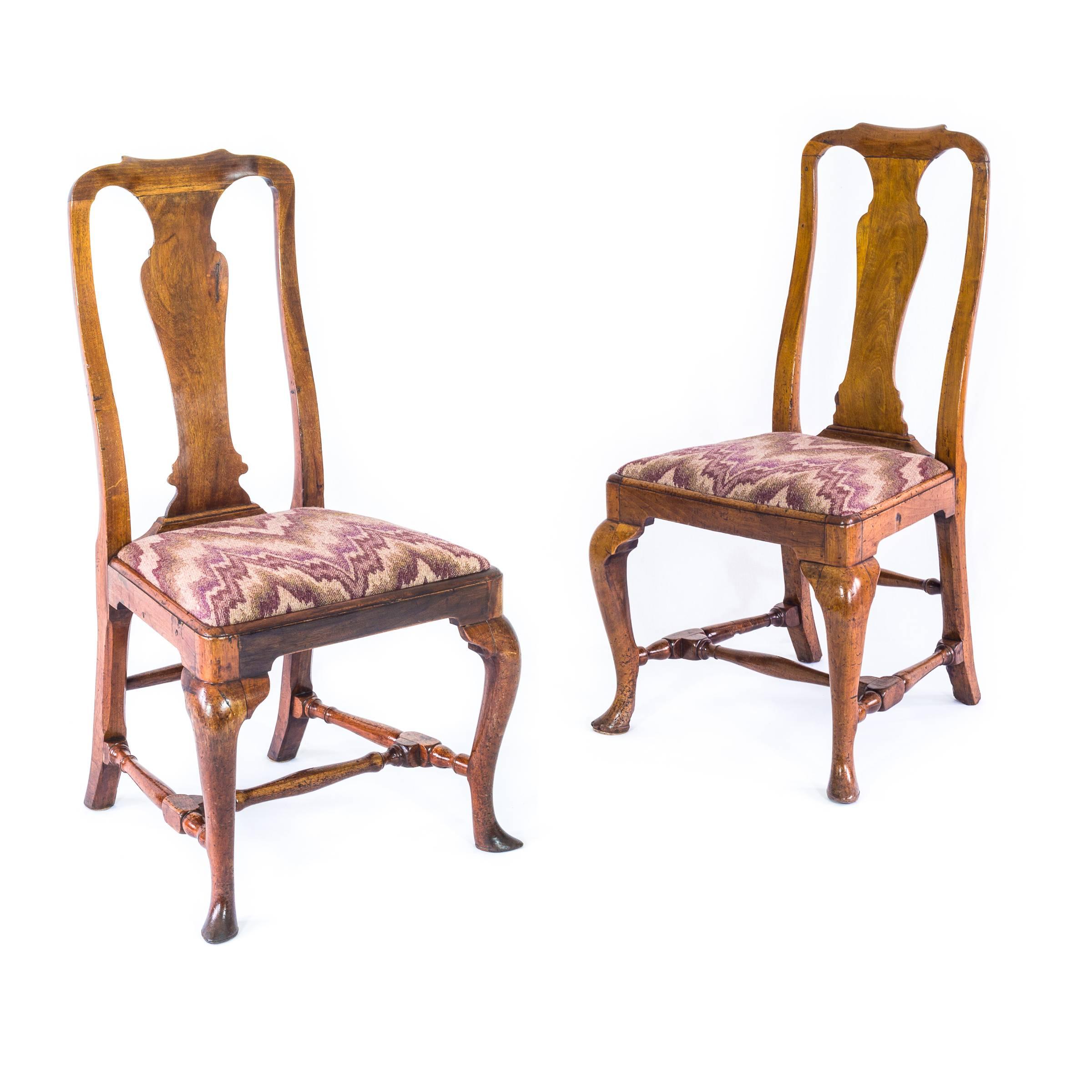 A good close pair of late Queen Anne - early George I period side chairs in walnut.

English, circa 1715.

The curved backs with fiddle-shaped splats and dished crest rails, above the moulded trapezoidal seats, raised on well shaped cabriole