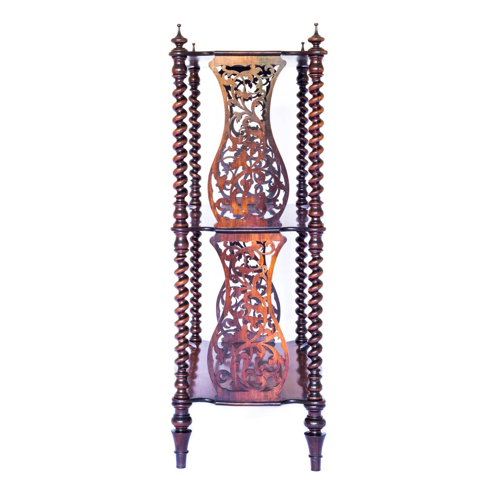 A most unusual early Victorian three tier mahogany etagere, or whatnot, with barley twist columns terminating in finials at the top, and elaborate frets between the serpentine shaped shelves, raised on four turned legs. 

English, c.