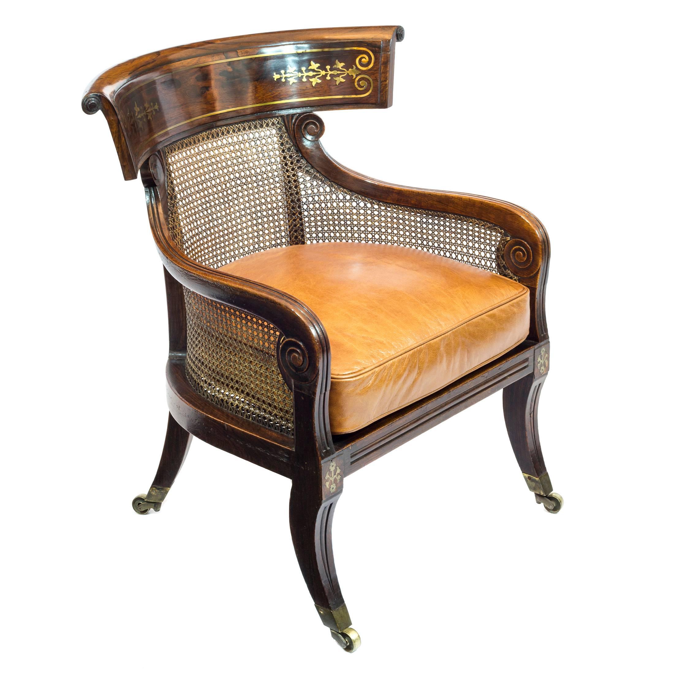 A fine Regency period simulated rosewood library tub Bergere, of Klismos form, attributed to William Wilkinson of Ludgate Hill, London.
 
English, circa 1815.
 
The open beech showframe, dark grained to simulate rosewood, caned throughout, having