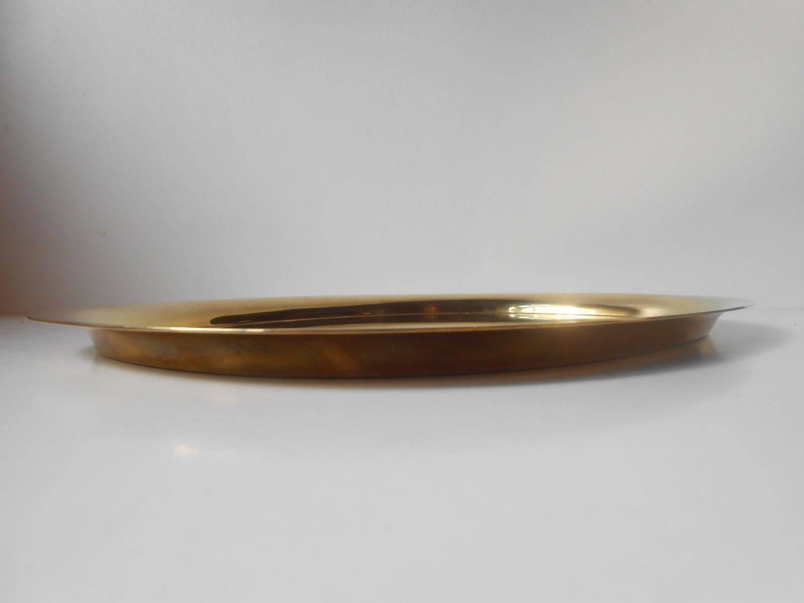 Measurements and infos:

Type: Large elliptical solid brass tray.

Lenght: 32,5 cm (approx. 13 inches).

Width: 24,7 cm (approx. 10 inches).

Material/color: brass slightly patinated.

Maker: Georg Jensen - Denmark.

Design: Piet