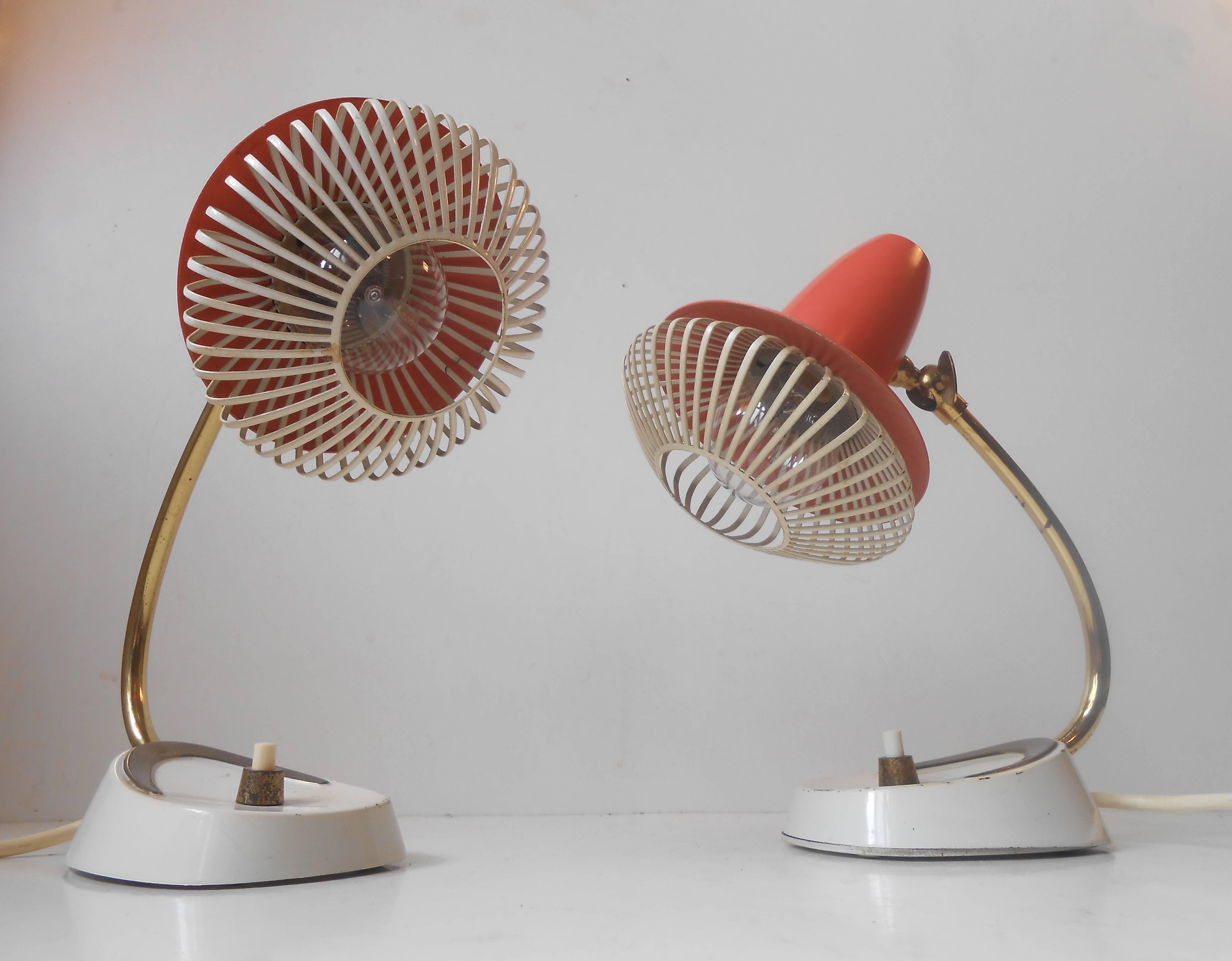 A pair of night table lamps with clay-red shading, brass Boomerang base details and light-softening shade baskets, possibly Swiss made in the style of Stilnovo. Measurements: H 9.5 inches (23.5 cm), D: (shades) 5.5 inches (13 cm). The price is for