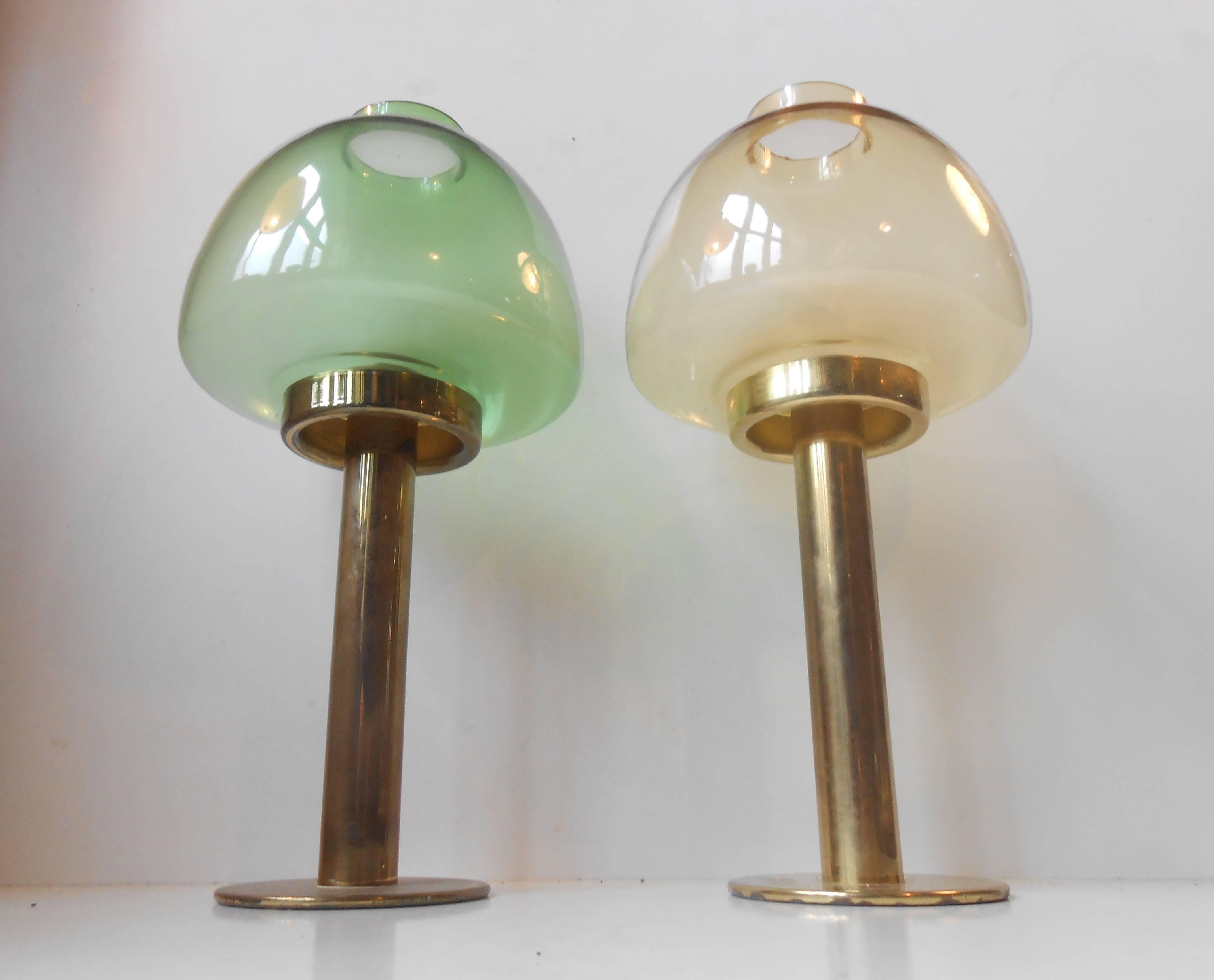 Pair of brass candleholders by Hans-Agne Jakobsson for Markaryd, Sweden, circa 1960. Model: L 102/32. Green and yellow glass. Spring-system that makes the candle set at the right height all the time. Diameter base is 10cm (4 inches), diameter glass