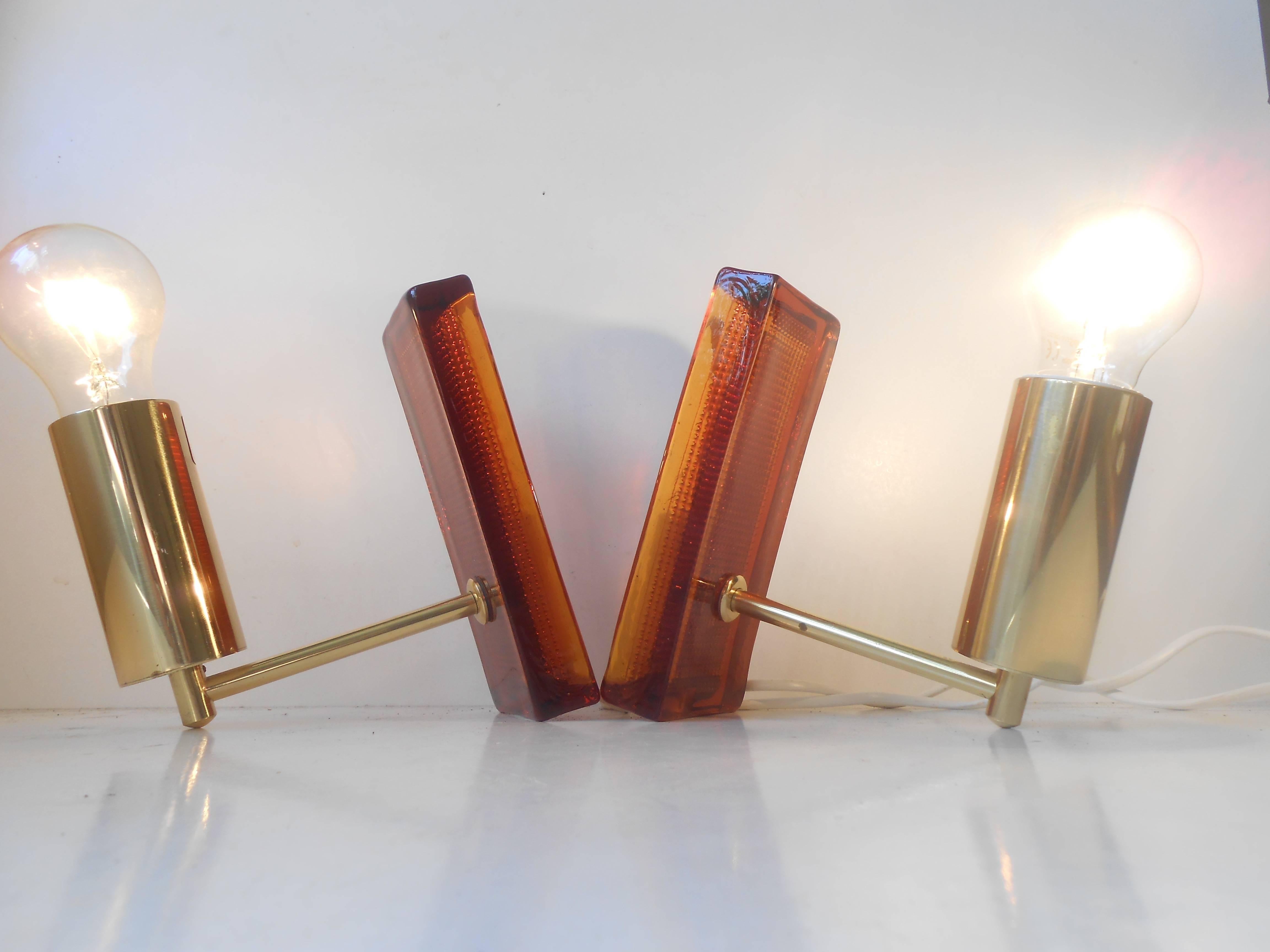 A rare pair of wall lights in gilded brass and amber glass. Measurements: Dept: 7 inches (18 cm), height: 8 inches (20 cm). Beautiful condition with no remarks. The price is for the pair.