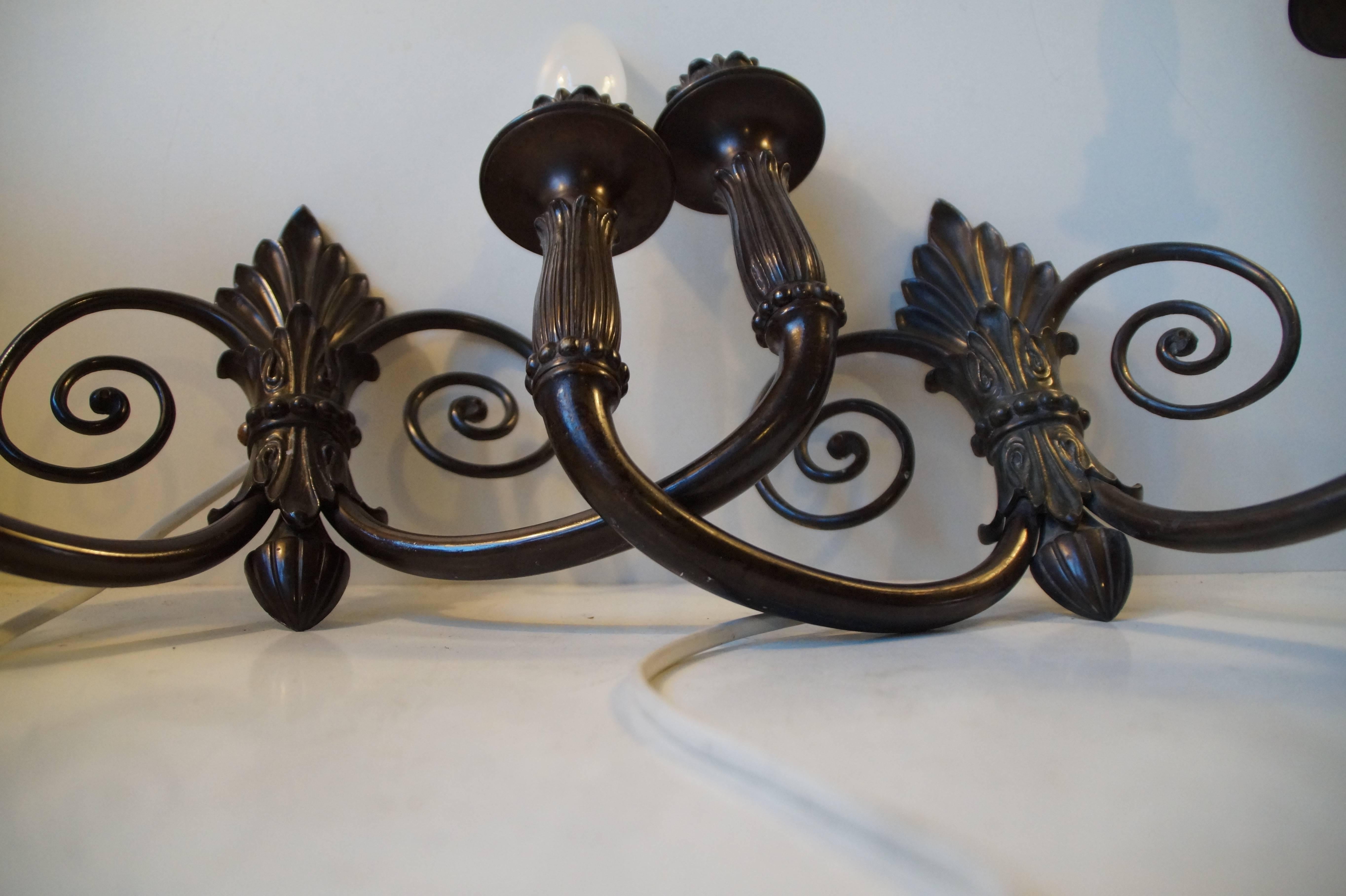 Exquisitely crafted pair of French two-armed sconces with superb detailing. Originally made as wall-candelabra. No alterations to the construction has been made so they are easily converted back to candelabra for candles. Please let us know if this