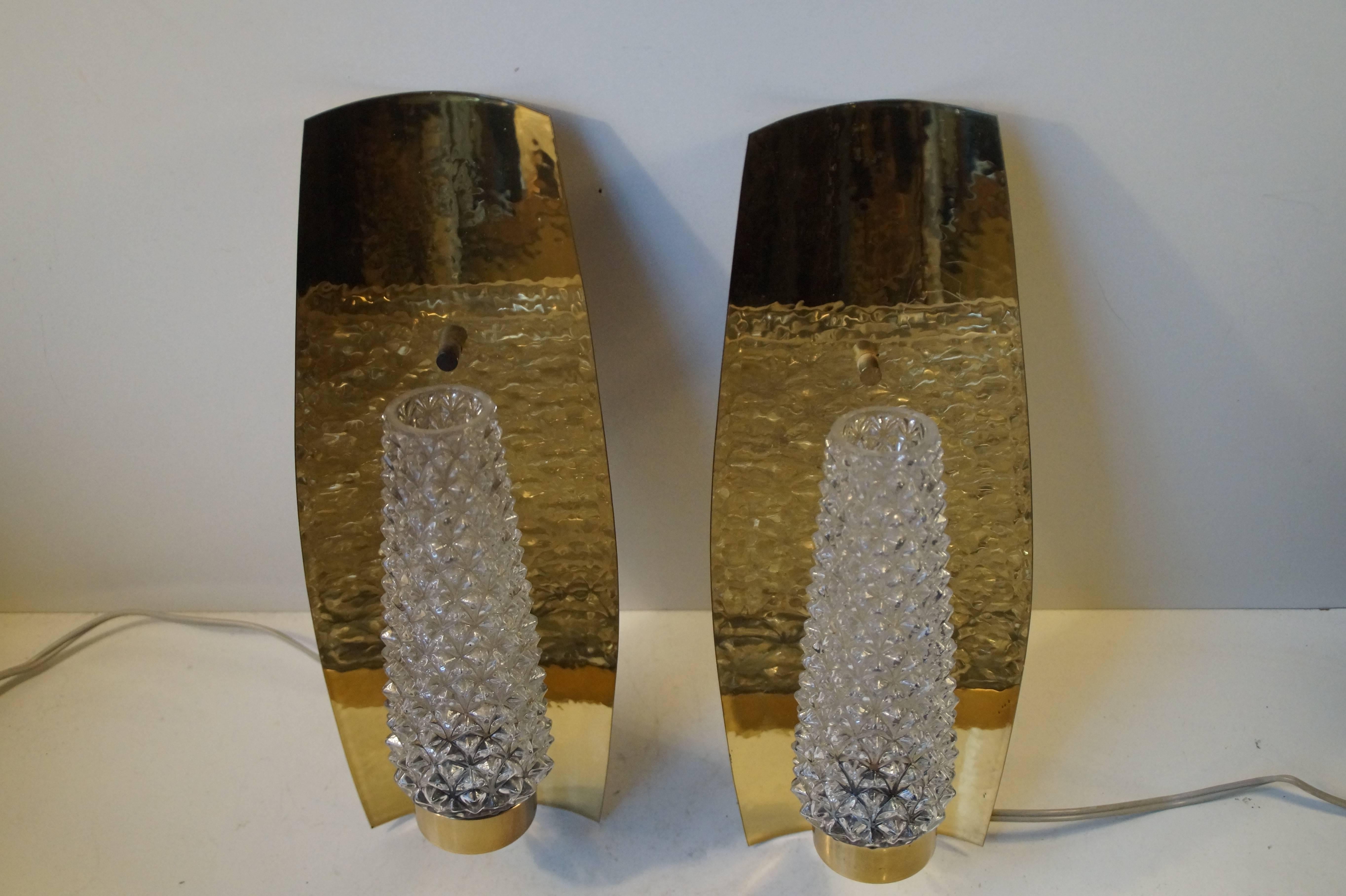 A pair of wall lamps in polished and slightly hammered brass with crystal shading by Hags. Beautiful clean design and splendid craftsmanship. Stamped: HAGS, 8180. Measurements: H 13 inches (33 cm), W 5 inches (12.5 cm). The price is for the Pair.