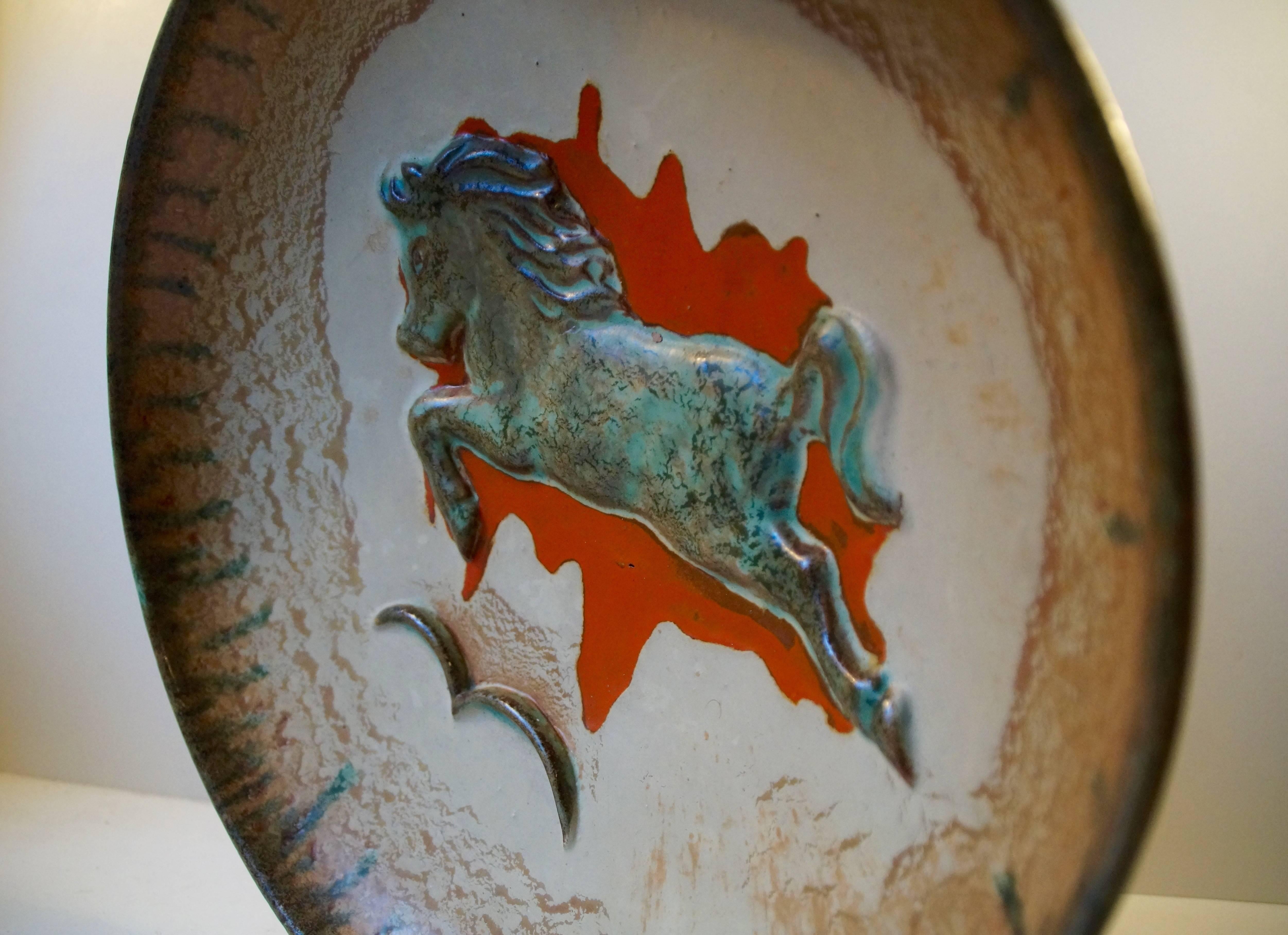 Massive and beautifully glazed stoneware bowl with 'jumping horse' centre motif executed with 'Verdigris green' glaze on a 'splatter' of red glaze. Designed by Swedish ceramist John Anderson (1899-1969) in the 1950s and manufactured by Höganas. A