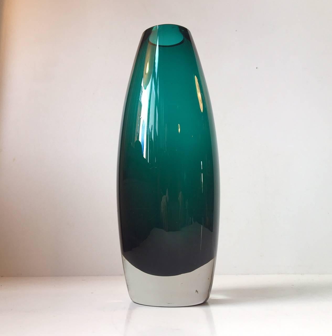 Mid-Century Scandinavian art glass vase designed by Tamara Aladin, for the maker Riihimaen Lasi Oy of Finland. The vase has a lovely cylindrical tapering form in a cased turquoise clear glass body. This piece is fully marked to the base with a