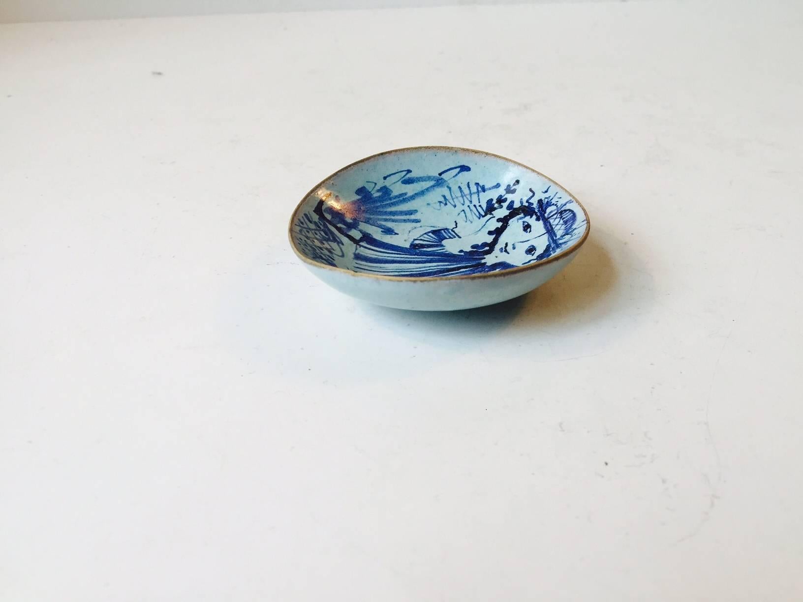 A very early ceramic miniature bowl or Salt Cellar made by Bjørn Wiinblad. A very delicate and fragile ceramic body hand-painted I blue glaze on a light blue background. It was made as a part of a dinner service commissioned as a gift to a unknown