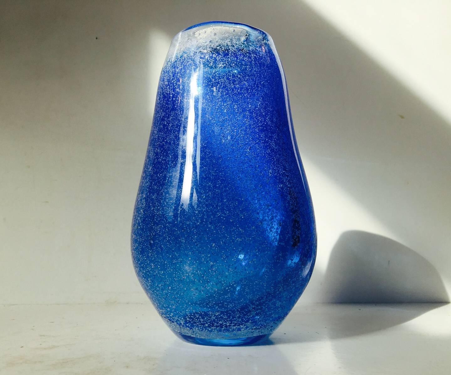 This cloudy blue galaxy art glass vase was by Bertil Vallien. It’s manufactured during the 1970s by Kosta Boda, Sweden. The cloudy spotted galaxy-like effect is created with air and white ash. Measures: Height 18.5 cm (7.3 inches), weight