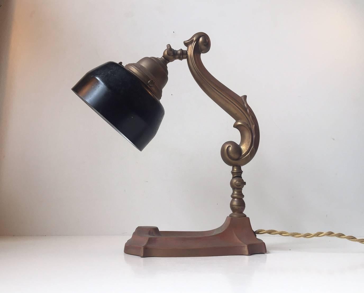 Ornate and beautifully made Danish, 1920s desk lamp with frame and base of patinated copper and brass. Its mounted with a black steel shade that may have been applied later on. It has its original porcelain fitting for E27 large lightbulb.