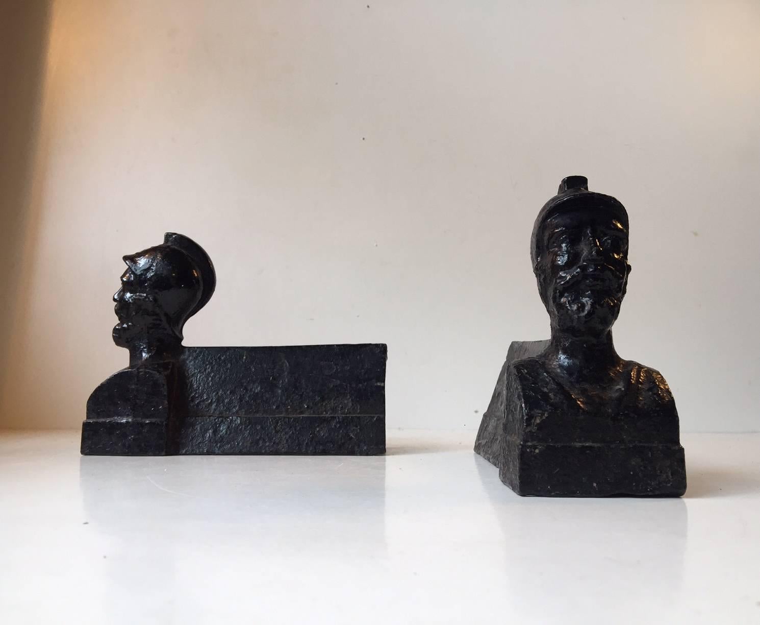 A pair of antique chenets or firedogs cast with a head and shoulders bust of a military Generals, with a straight, pyramidal billet bar. With their relatively small-scale they could be adapted for other decorative uses in the home such as bookends.