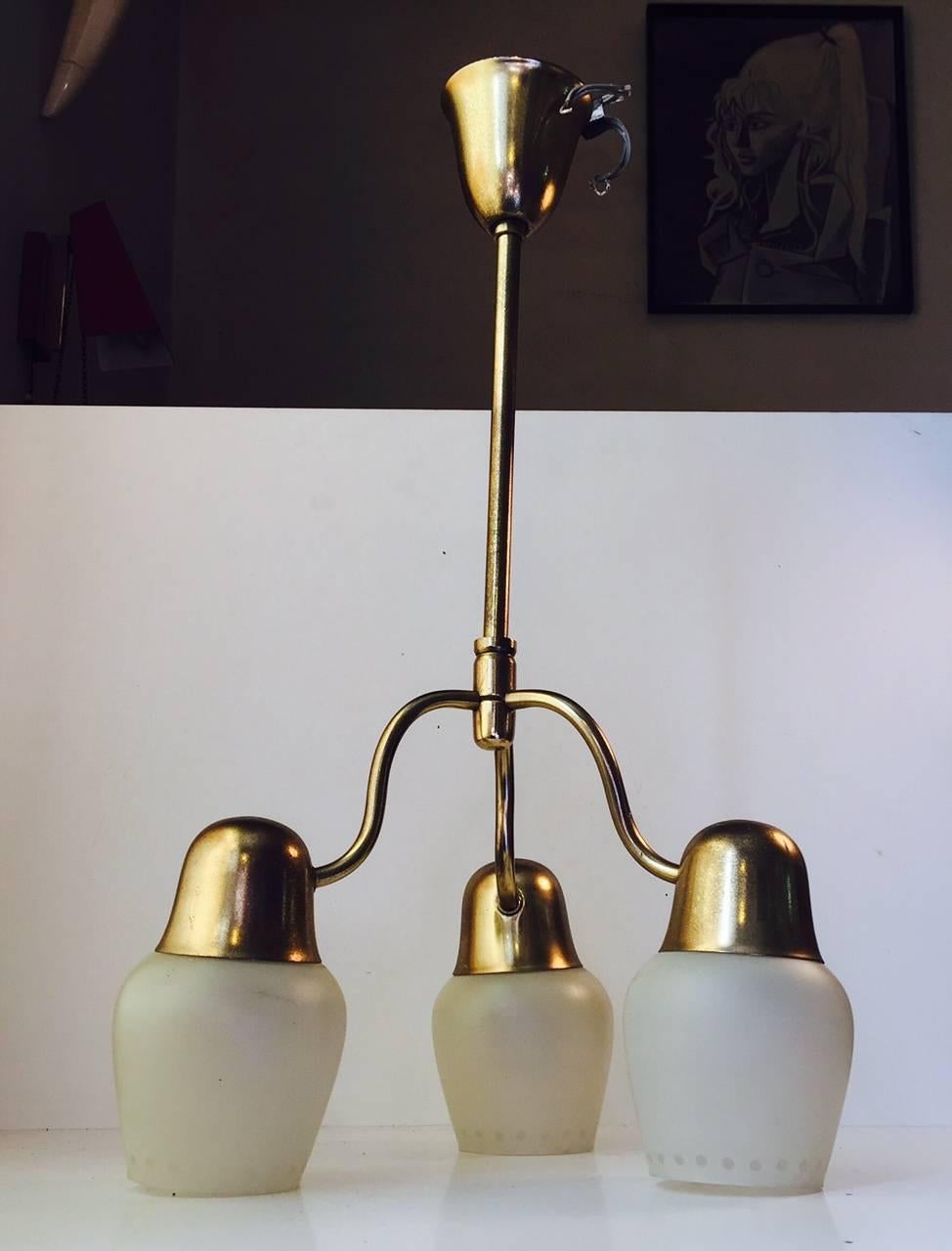 A round brass ceiling light with three dotted opaline glass shades. It features organic shapes and curves and was manufactured by ASEA in Sweden during the 1940s or early 1950s in a style reminiscent of Hans Bergstrom and Vilhelm Lauritzen. It has a