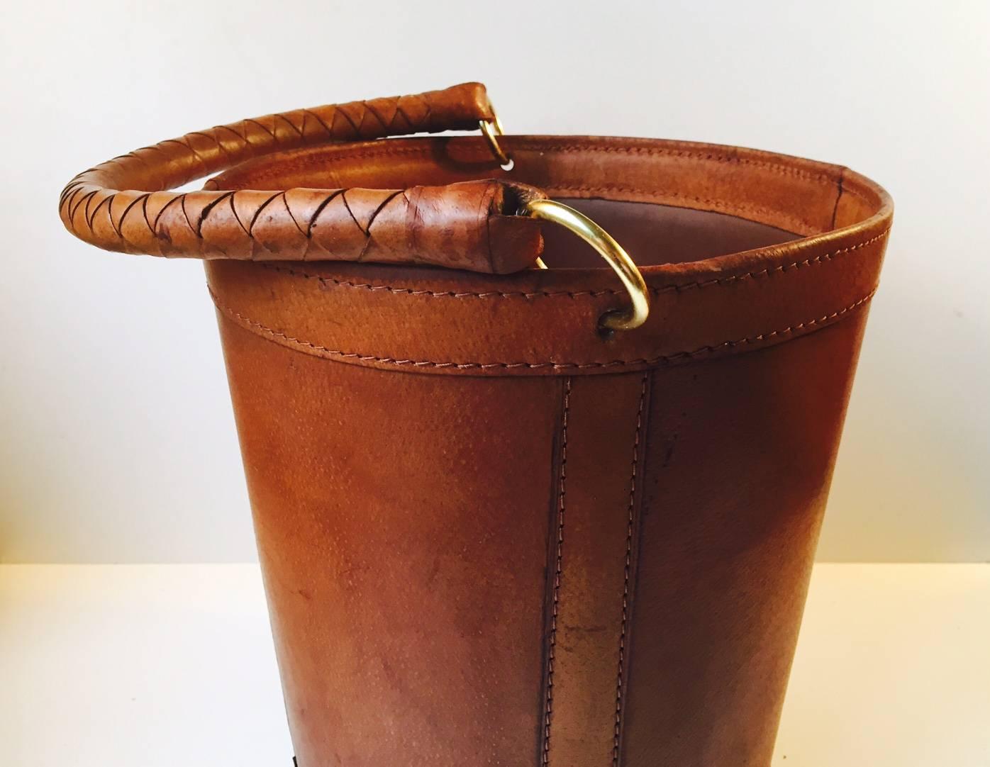 Paper waste bin / Champagne bucket in thick tanned, patinated, partially braided leather and brass designed for Illums Bolighus in the 1950s in a style reminiscent of Carl Aubock and Jacques Adnet.