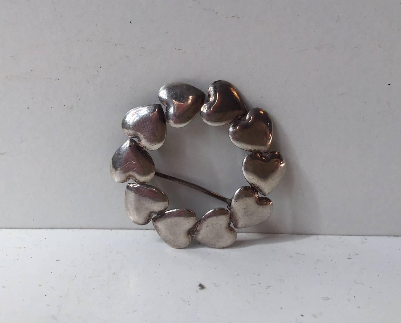 Brooch composed of ten connected hearts designed by Hans Hansen of Denmark (1884-1940) circa 1930s; measuring approximate 1.5” in diameter; marked: 830 S. Rare, highly collectible, chic and timeless, the perfect gift for that special someone.