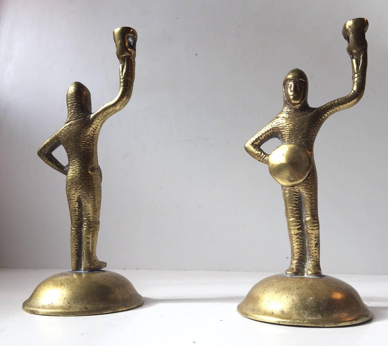 Pair 19th century bronze figural candlesticks in shape of Arthurian knights of the middle Ages in full armor holding their shields. These are to be fitted with small candles (Dia. 1 cm). The surface of the pair has been polished to a shine.