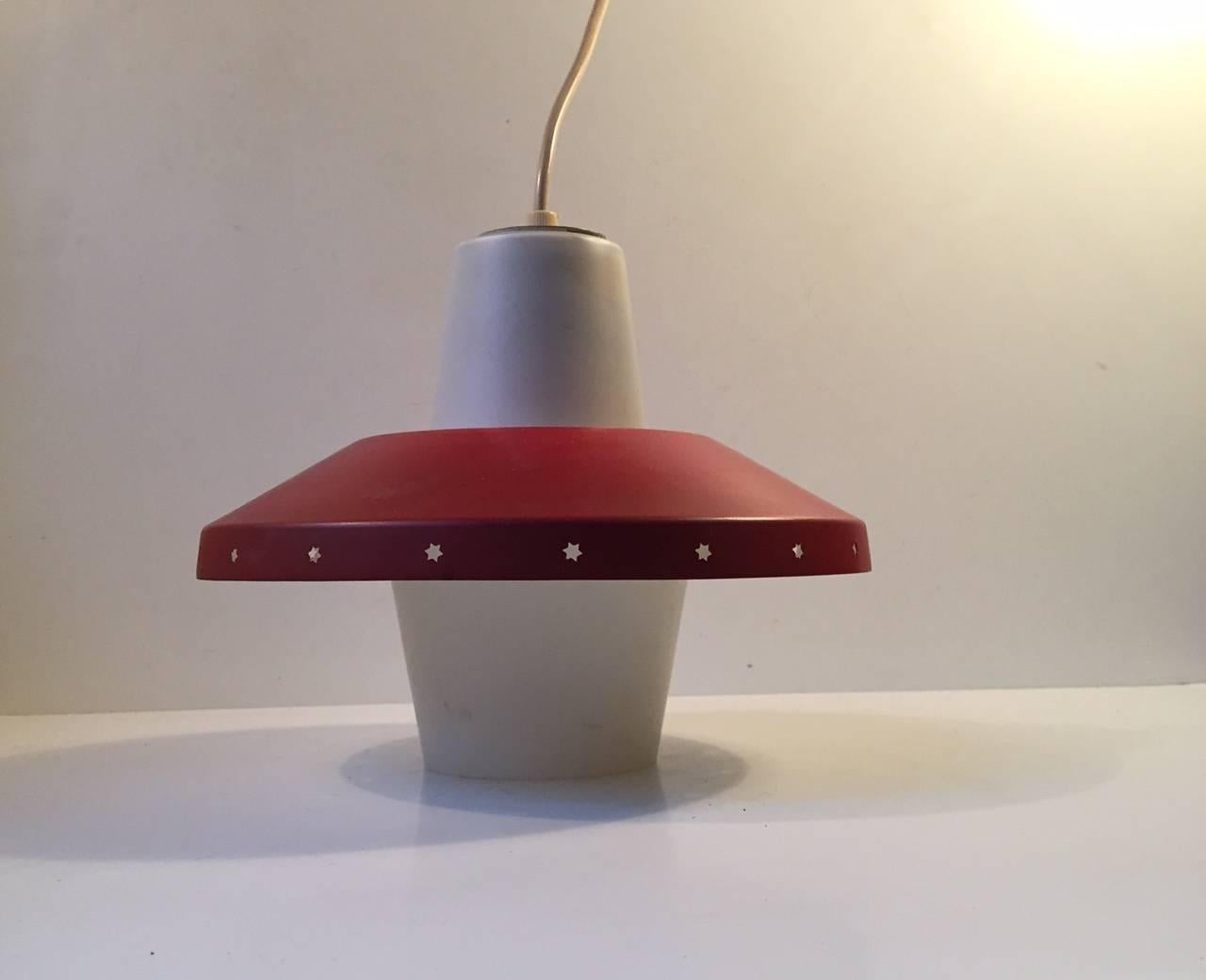 Danish ceiling light designed by Bent Karlby for Lyfa, Denmark and manufactured in the late 1950s. The light consists of red lacquered shade with perforated Stars to the edge and a bell clock shaped opaline glass center. Very nice vintage condition